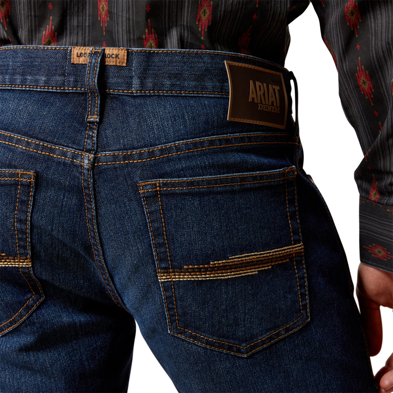 Close-up of blue jeans with Ariat logo on a white background