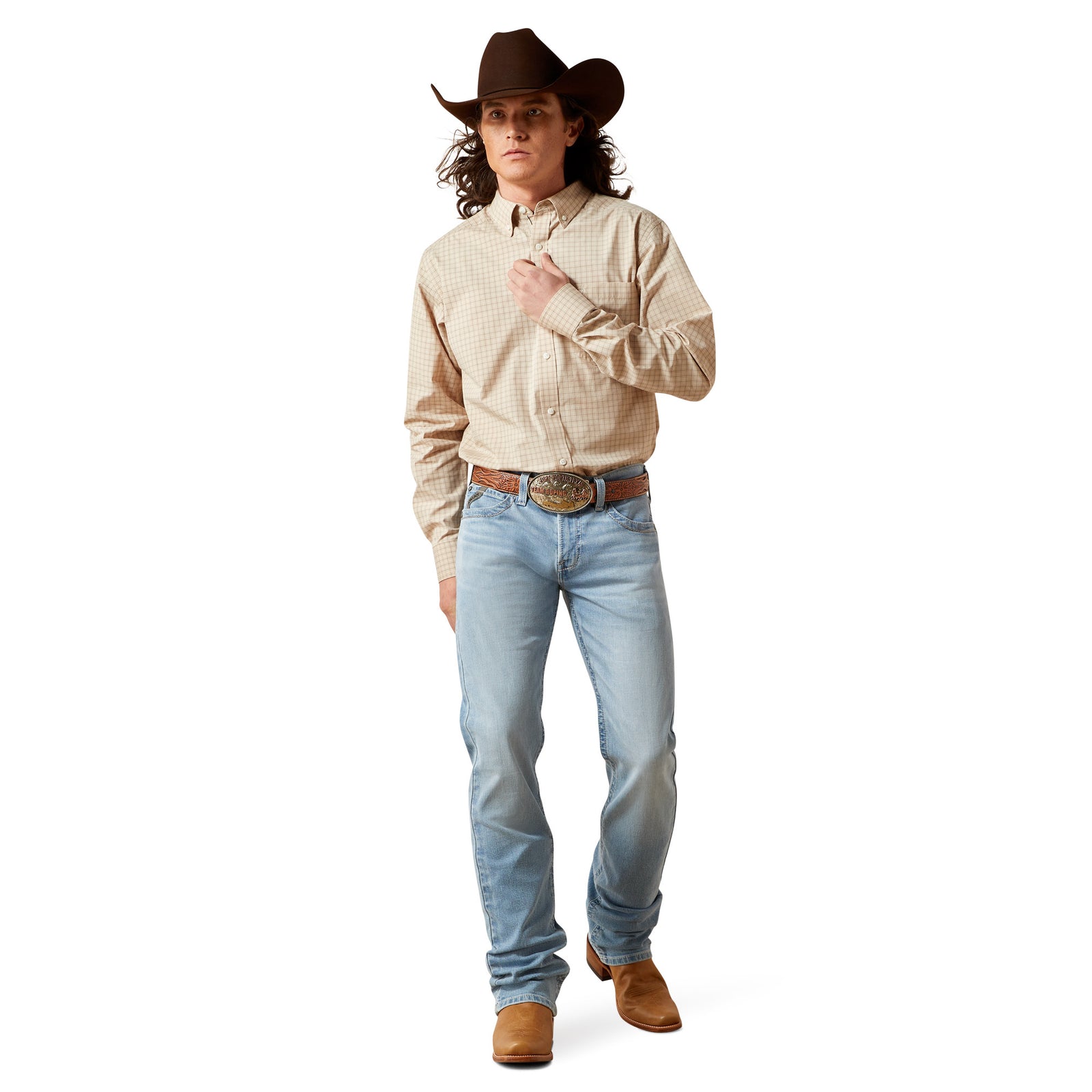 Man wearing a beige shirt, light blue jeans, brown boots, and a cowboy hat on a white background