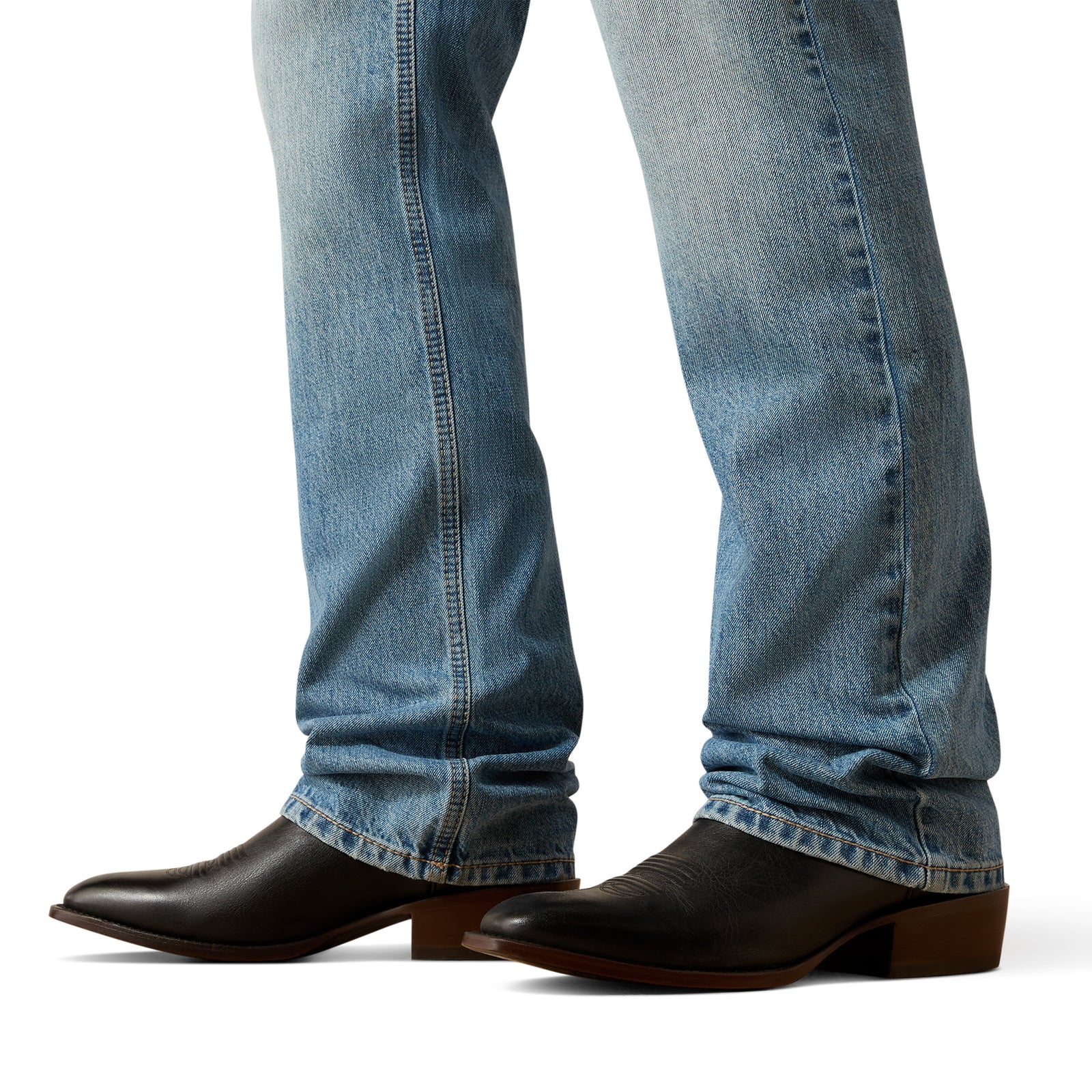 Close-up of blue jeans and black cowboy boots on a white background