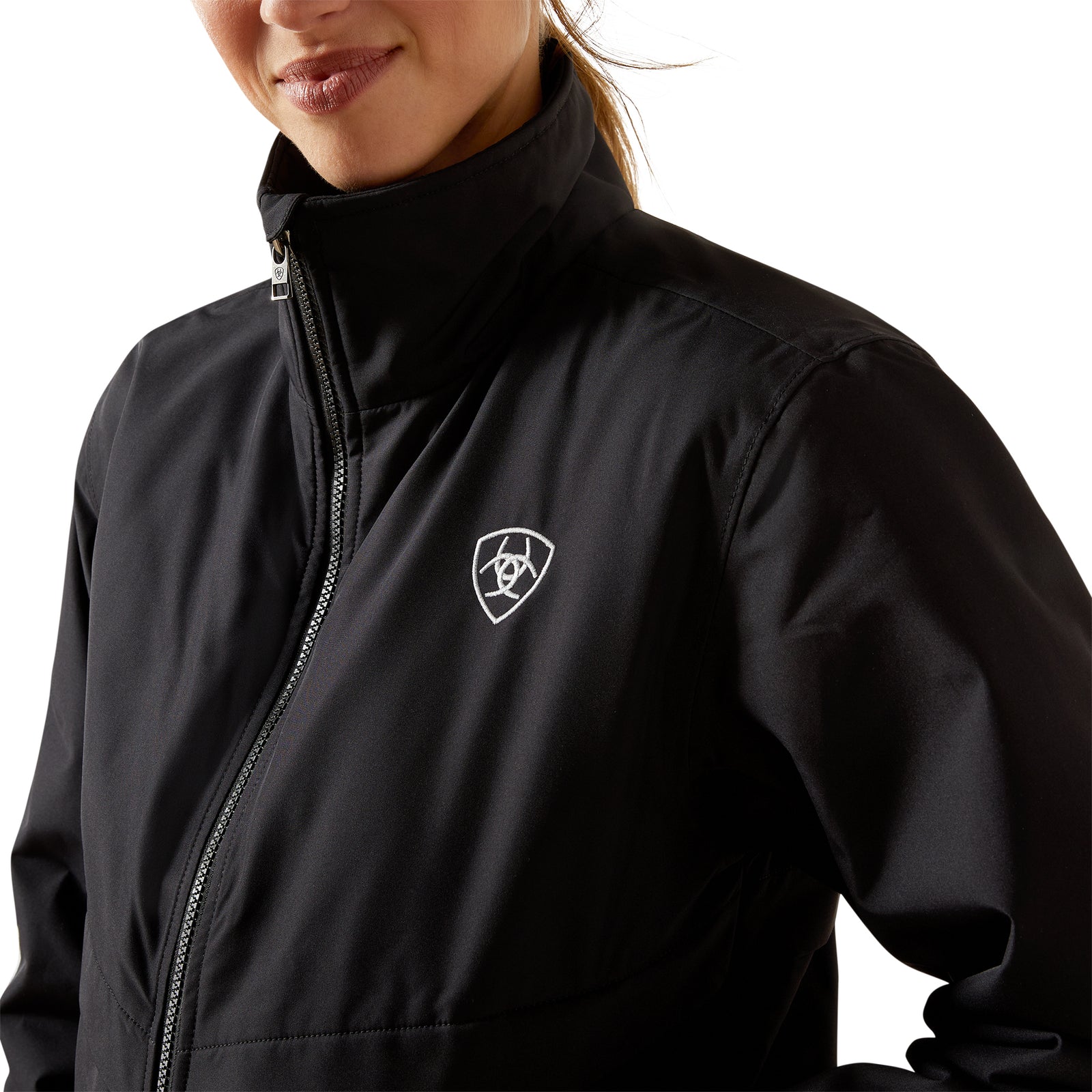 Person wearing a black jacket with a logo on the chest against a white background