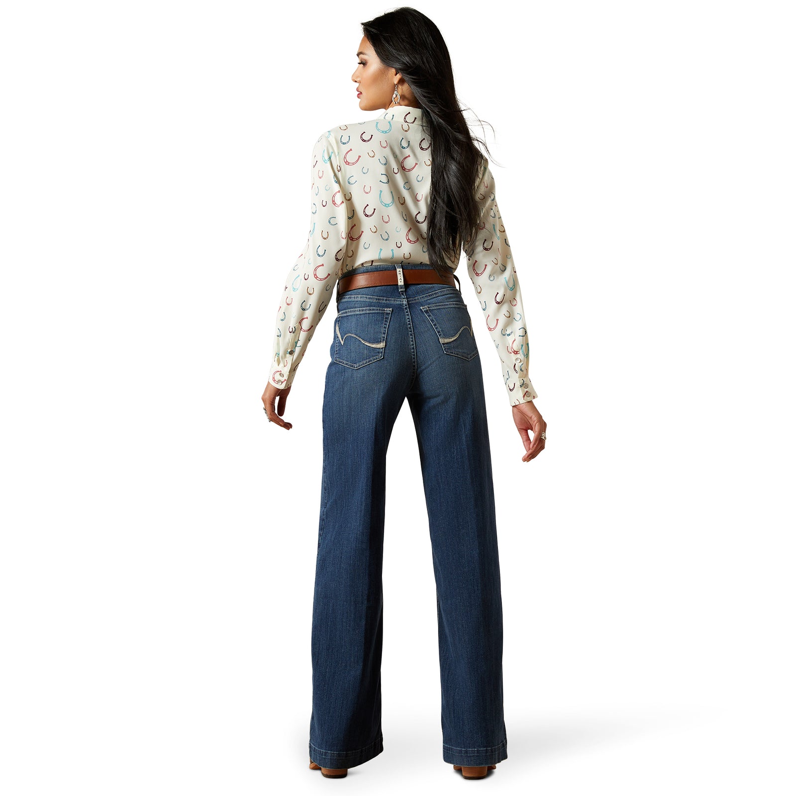 Ariat Women's Rosalie Ultra High Rise Wide Leg Jean. Woman wearing a patterned blouse and blue jeans on a white background