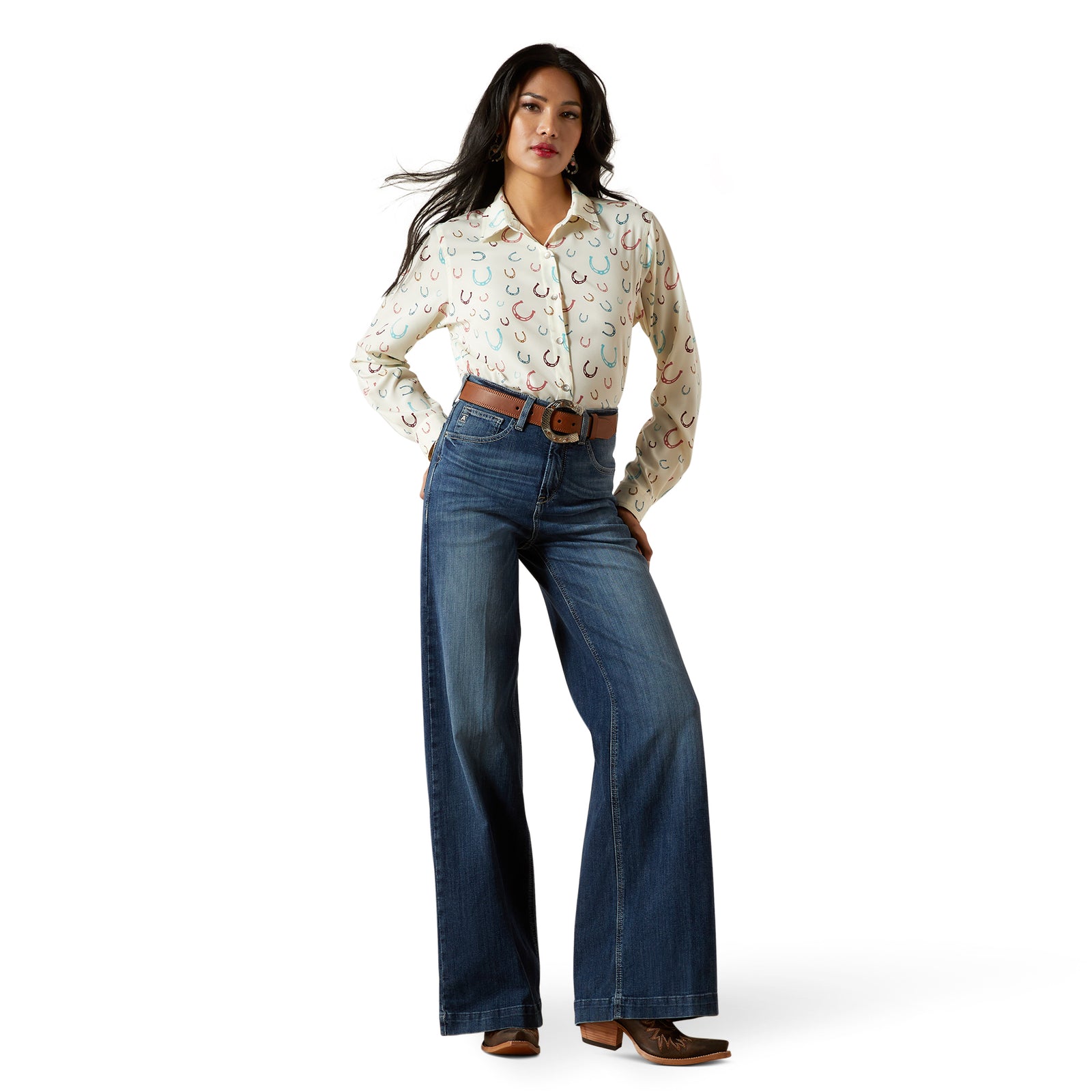 Ariat Women's Rosalie Ultra High Rise Wide Leg Jean. Woman wearing a patterned blouse and blue jeans on a white background