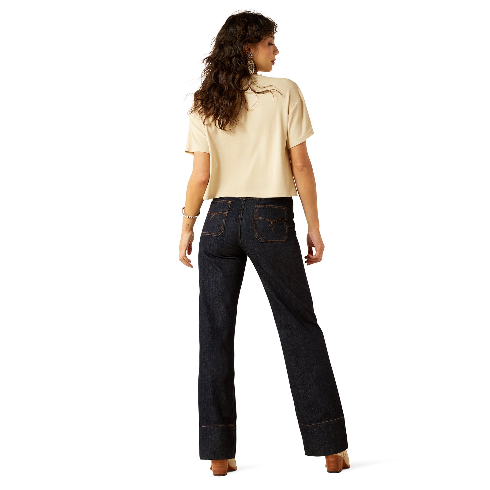 Ariat Women's Western Utility Ultra High Rise Tomboy Wide Leg Jean. Woman wearing a beige top and dark jeans on a white background
