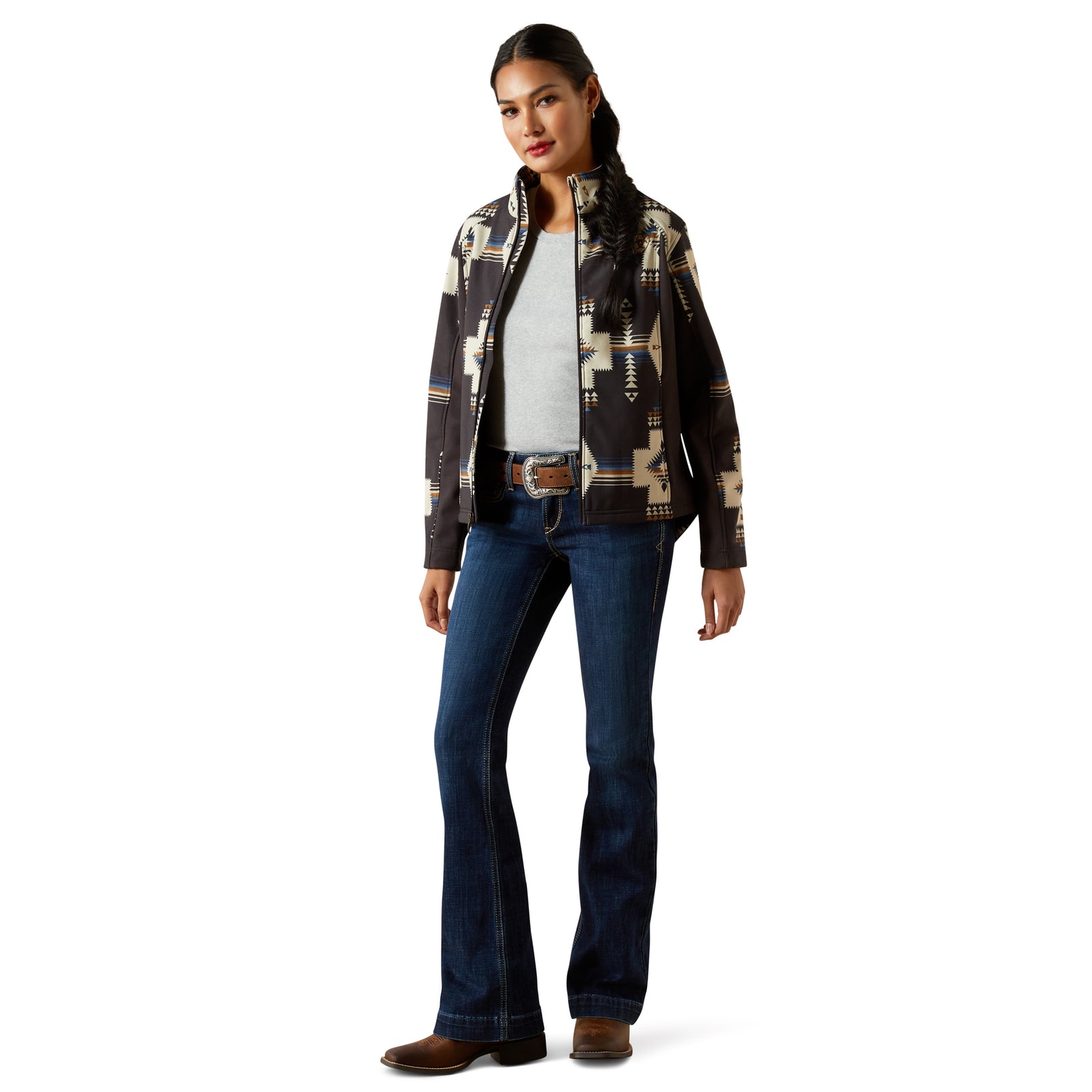 Woman wearing a patterned jacket and blue jeans on a white background