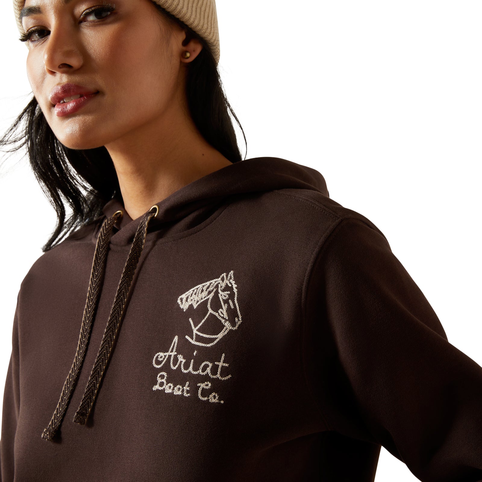 Person wearing a brown hoodie with 'Ariat' logo on a white background