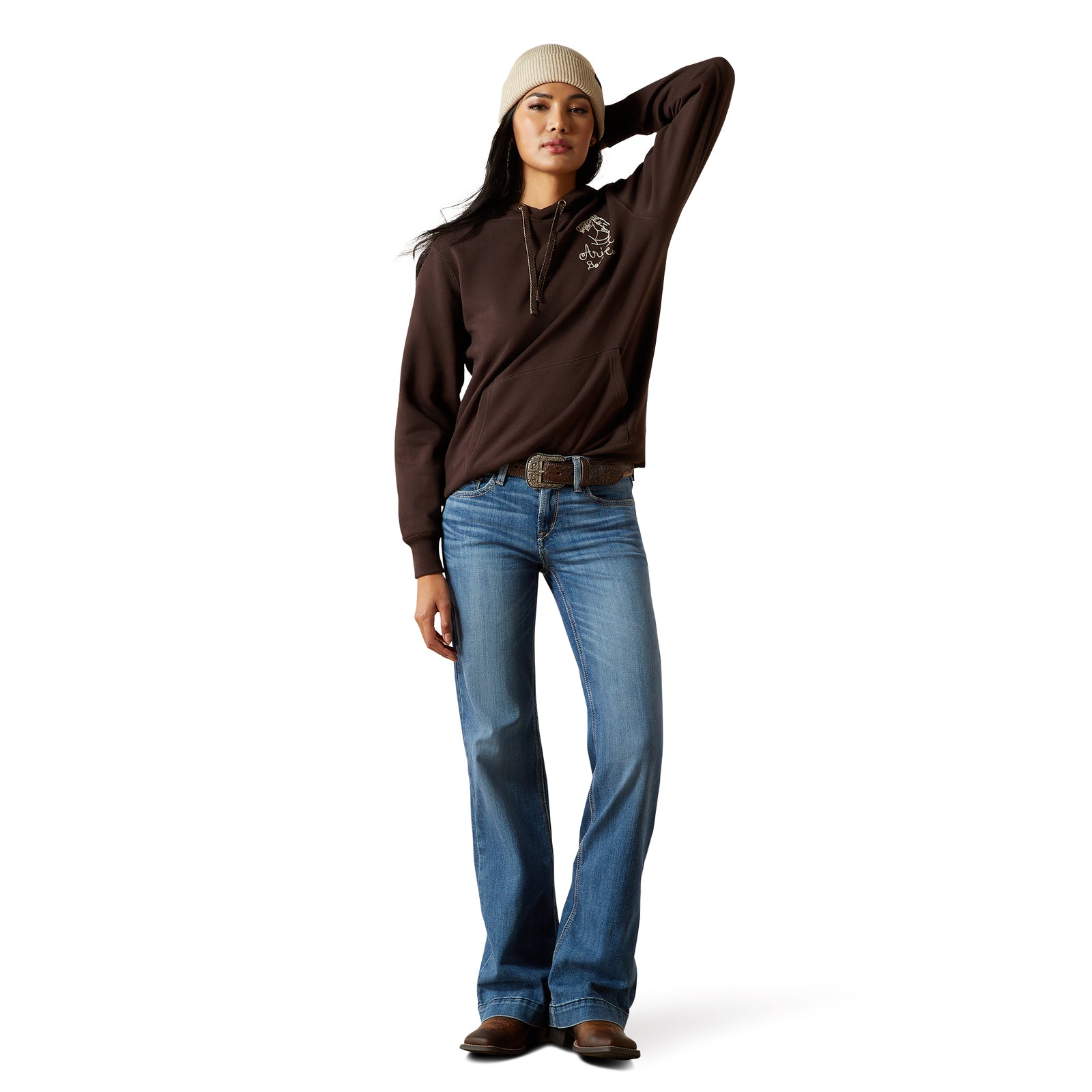 Woman wearing a brown long-sleeve shirt and blue jeans on a white background