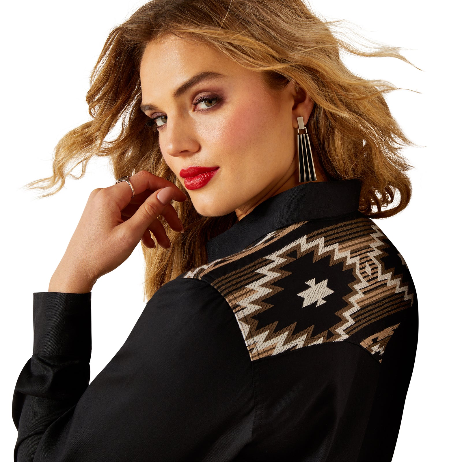 Woman wearing a black outfit with a patterned shoulder design on a white background