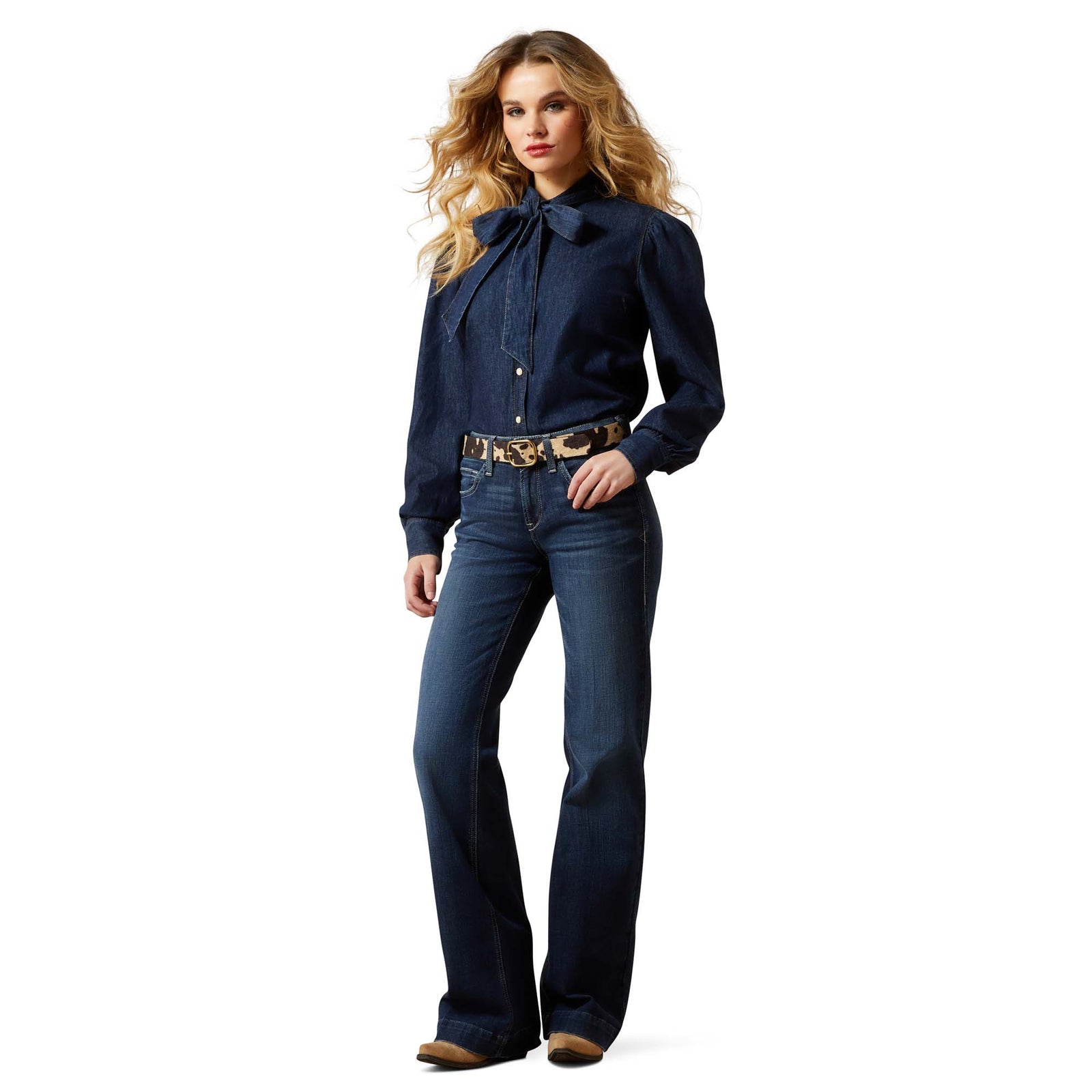 Woman wearing a dark blue denim shirt and jeans on a white background