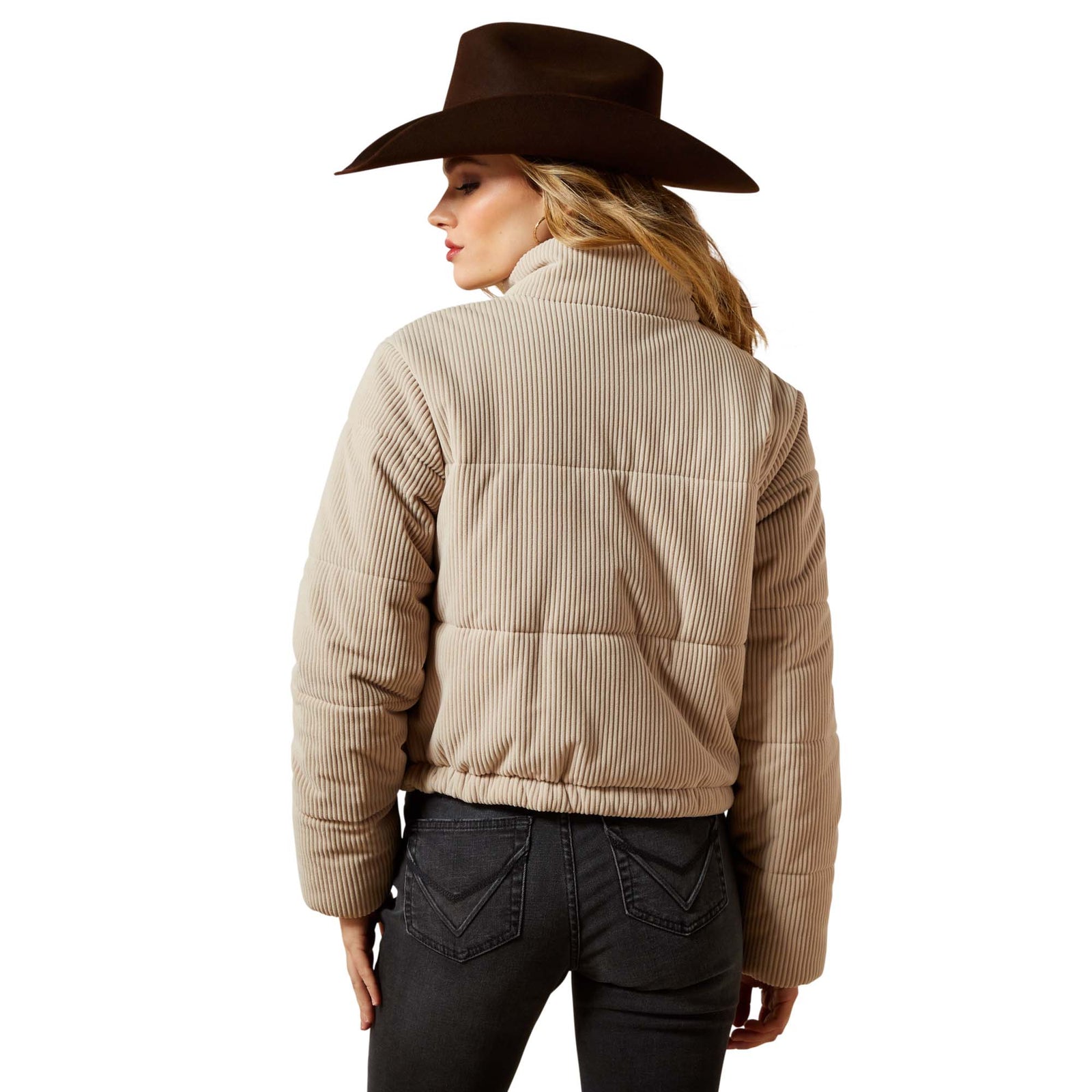 Person wearing a beige puffer jacket and brown cowboy hat on a white background
