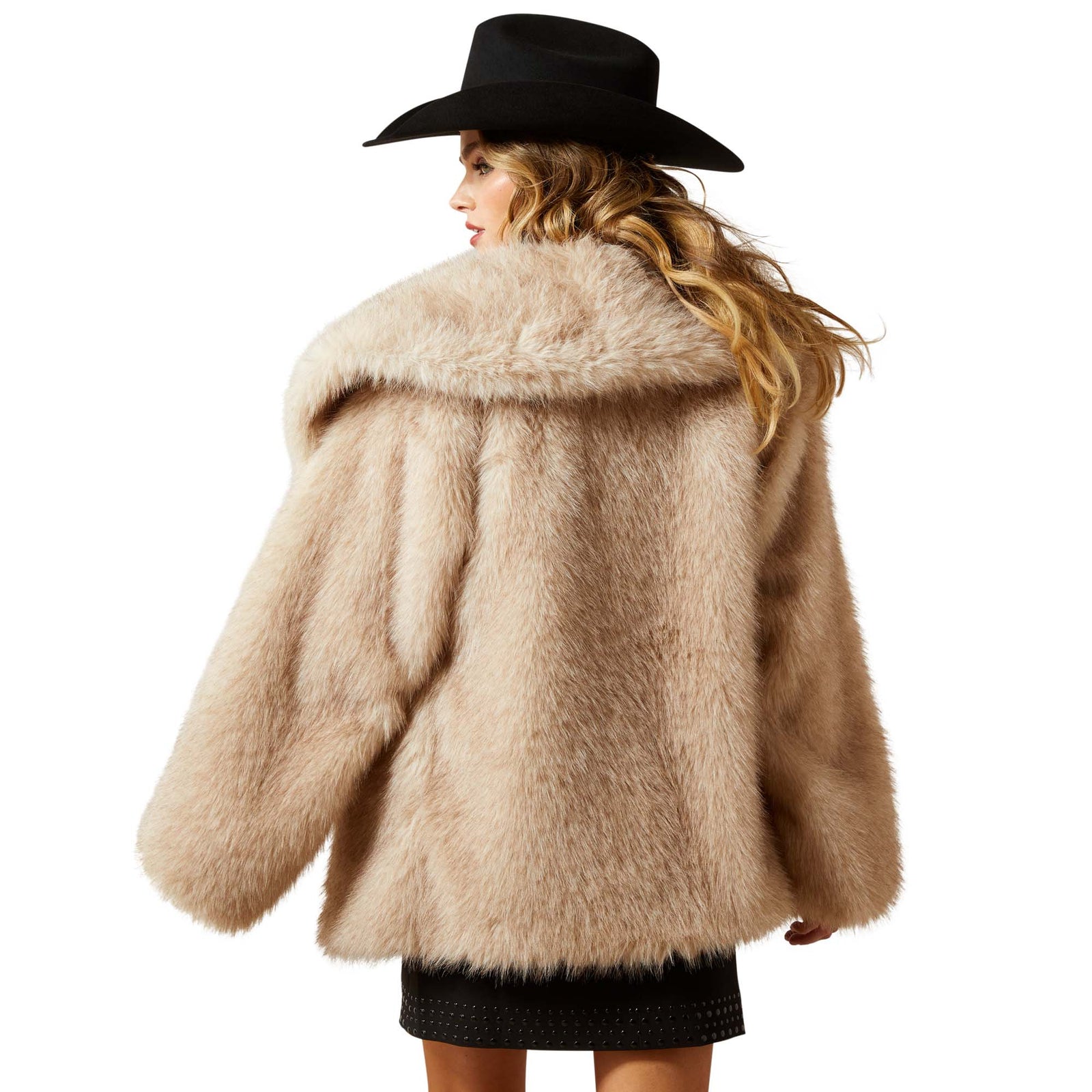 Person wearing a beige fluffy coat and black hat on a white background