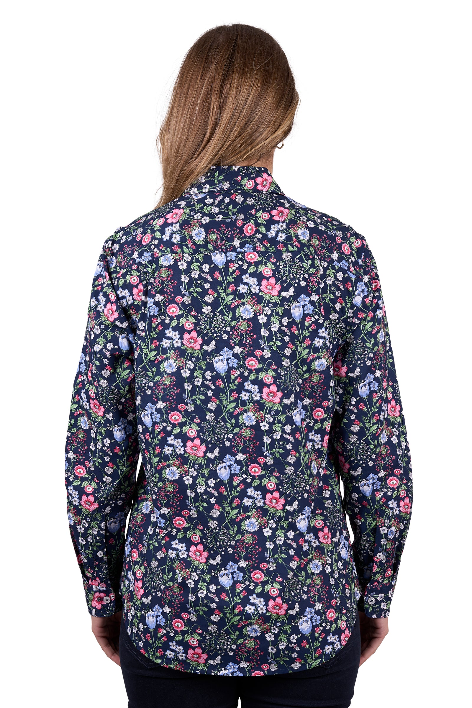 Hard Slog Women's Raya 1/2 Placket L/S Shirt. A woman wearing a long sleeve floral shirt with a half placket and two pockets, the shirt has contrast inside collar stand and sleeve cuffs, and logo buttons.