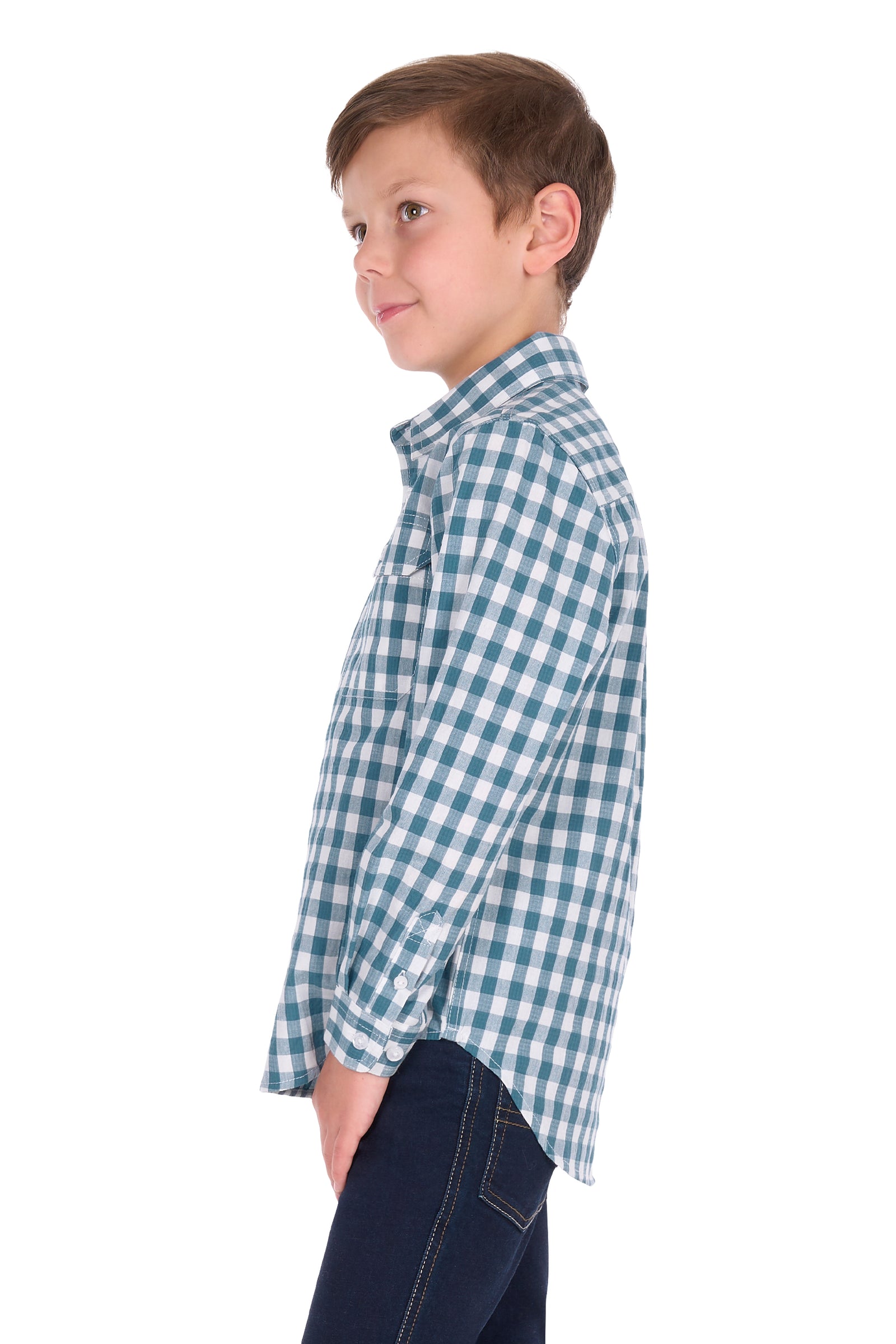 A young boy in profile wearing a blue and white gingham long-sleeve button-down shirt and dark jeans, photographed against a solid white background.