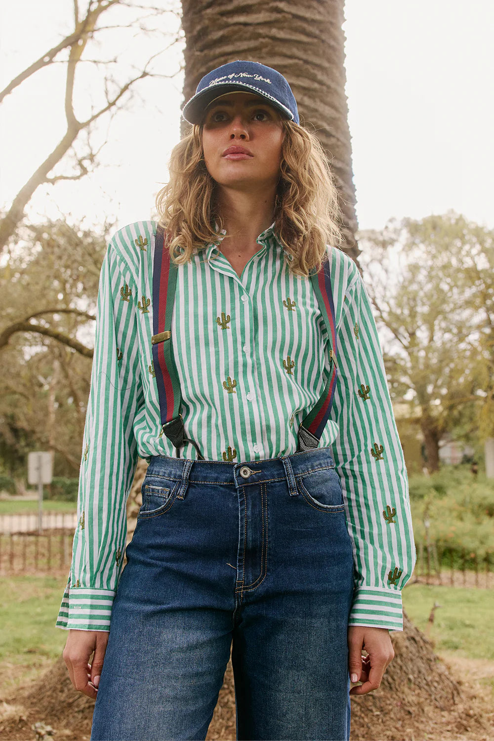 Italian Star Women's Stripe Cactus Shirt. Person wearing a green and white striped shirt with suspenders and a blue cap outdoors.