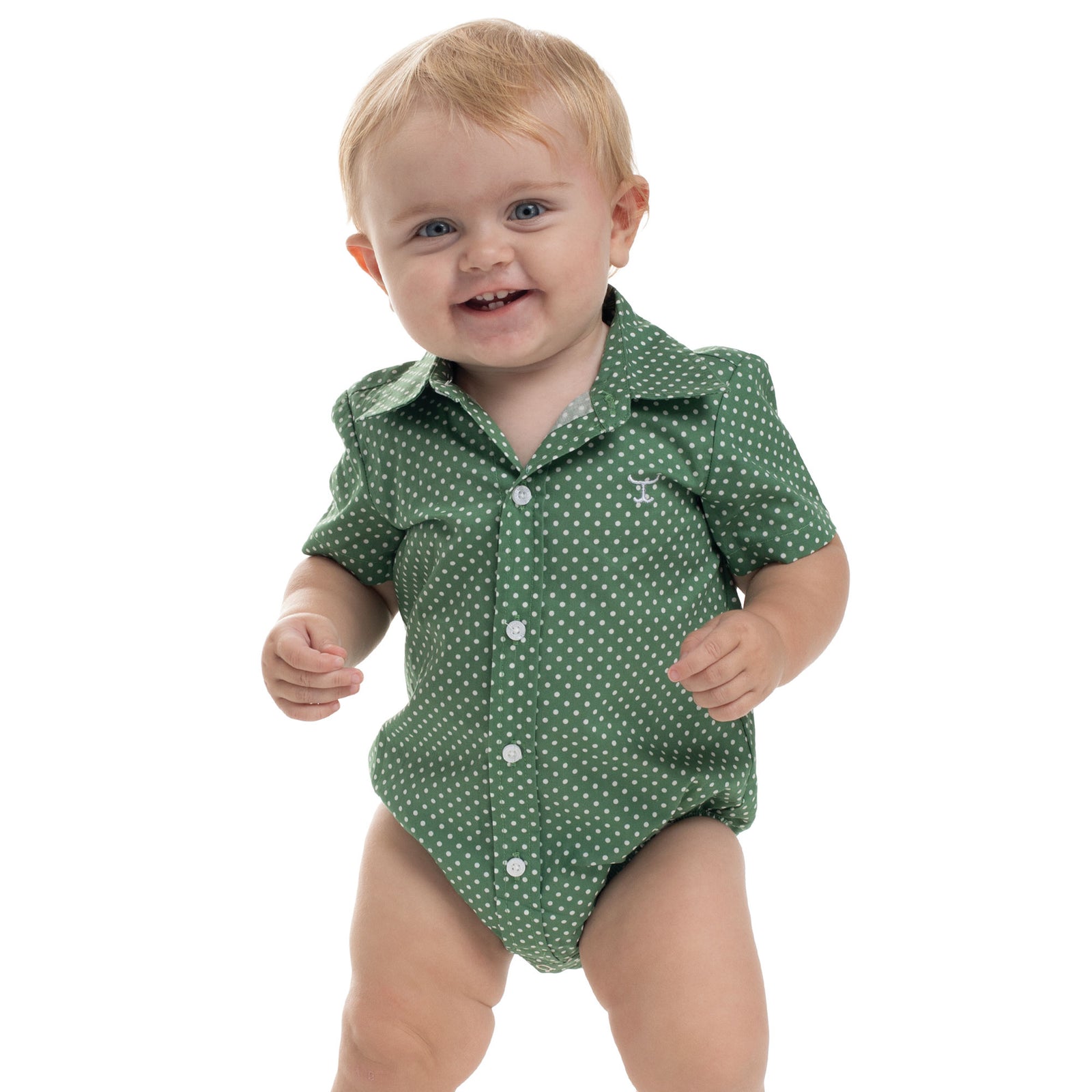 Baby wearing a green polka dot onesie on a white background