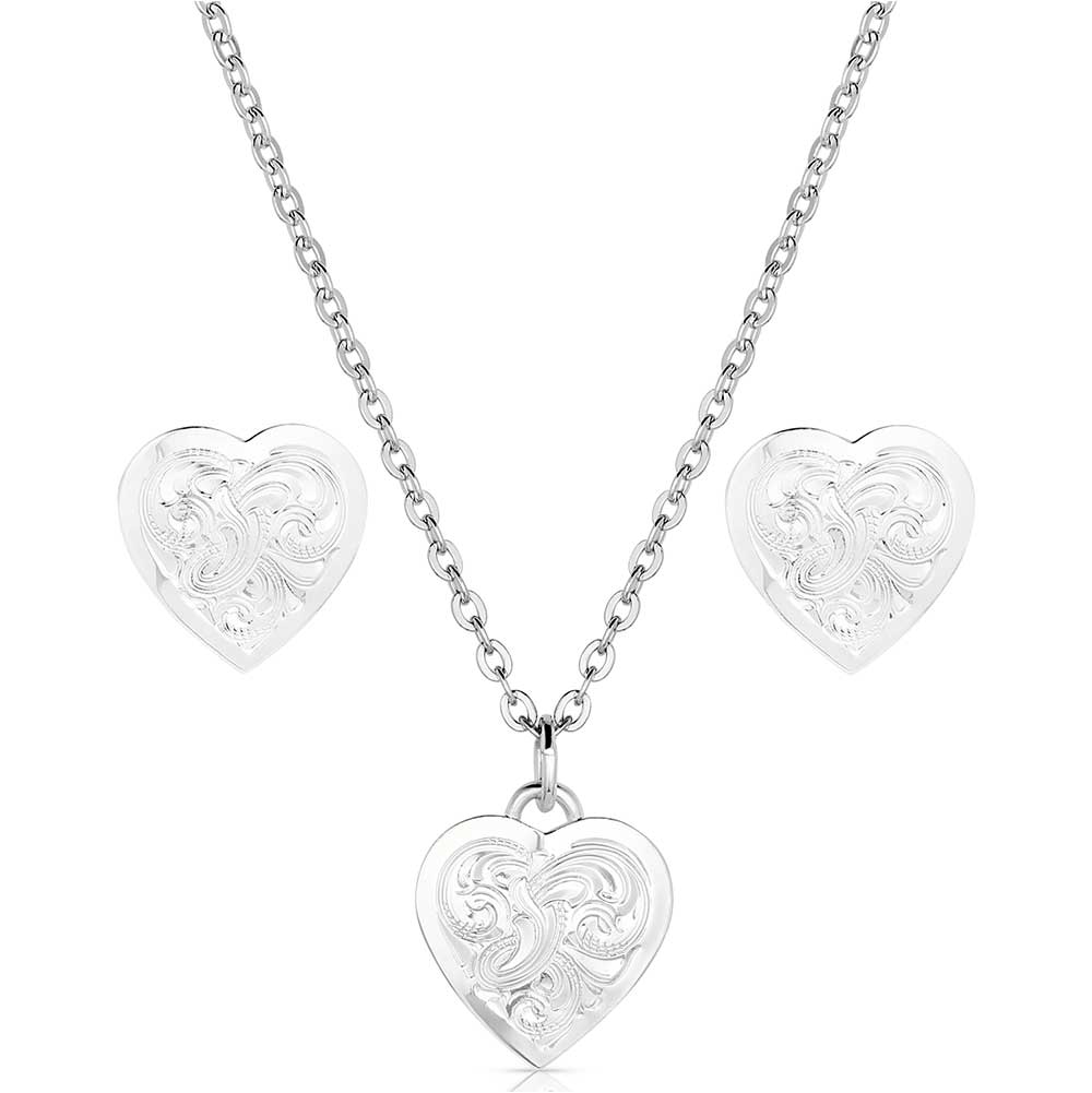 Montana Silversmiths Pure Heart Jewelry Set. A silver jewelry set including a heart-shaped pendant necklace and matching earrings with an engraved floral pattern.