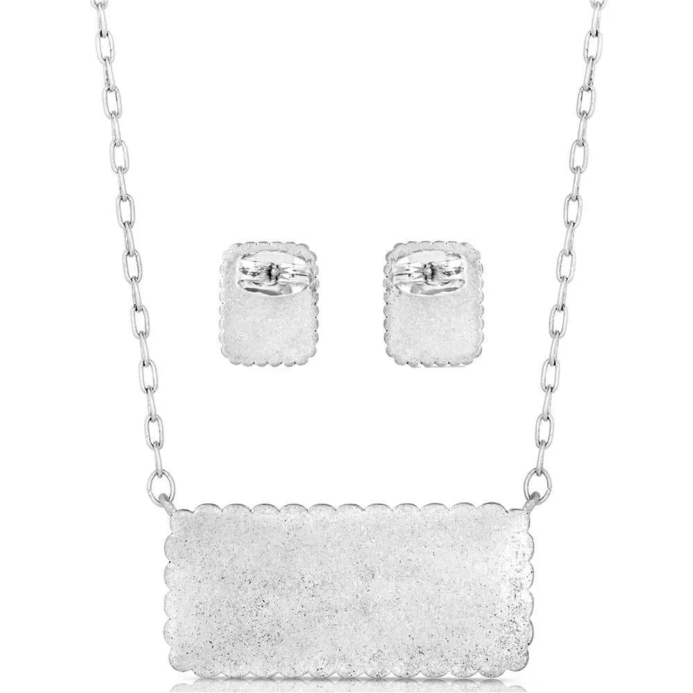 Silver jewelry set with necklace and earrings on a white background