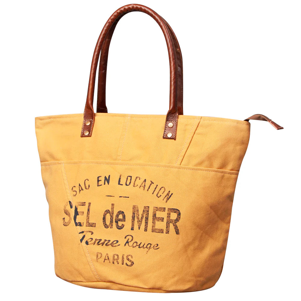 American Darling Upcylced Canvas Weekender Bag. Yellow tote bag with brown handles and text on a white background