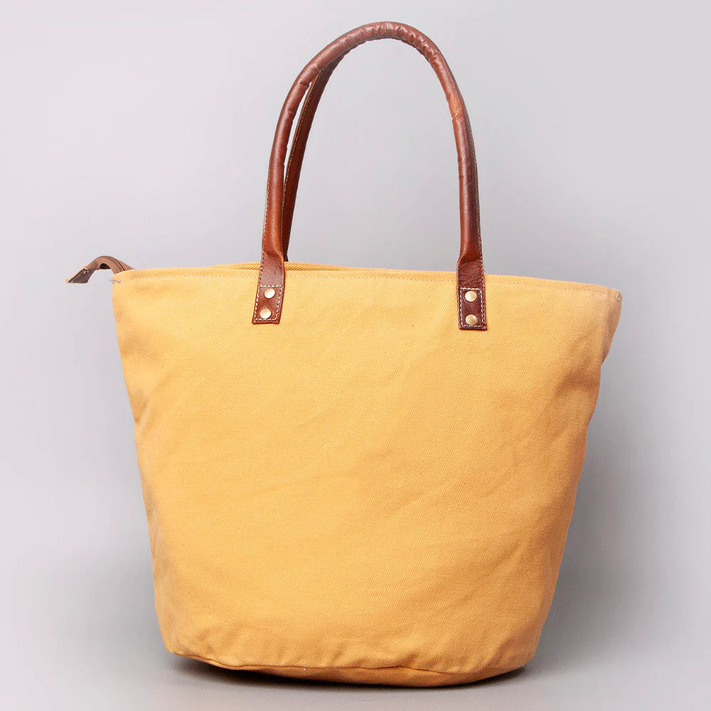 American Darling Upcylced Canvas Weekender Bag. Yellow tote bag with brown handles on a light gray background