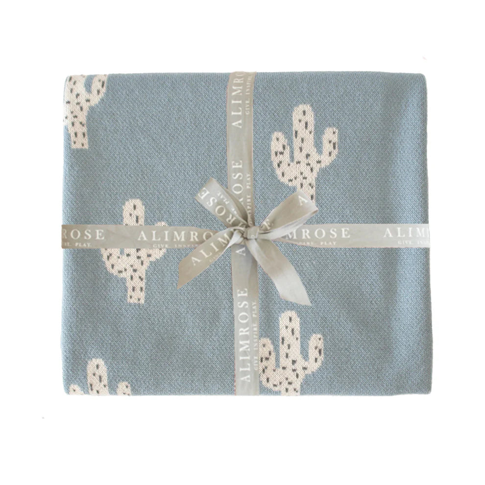 Alimrose Cactus Baby Blanket Blue. Blue fabric with cactus pattern and a ribbon, branded 'Alimrose'.