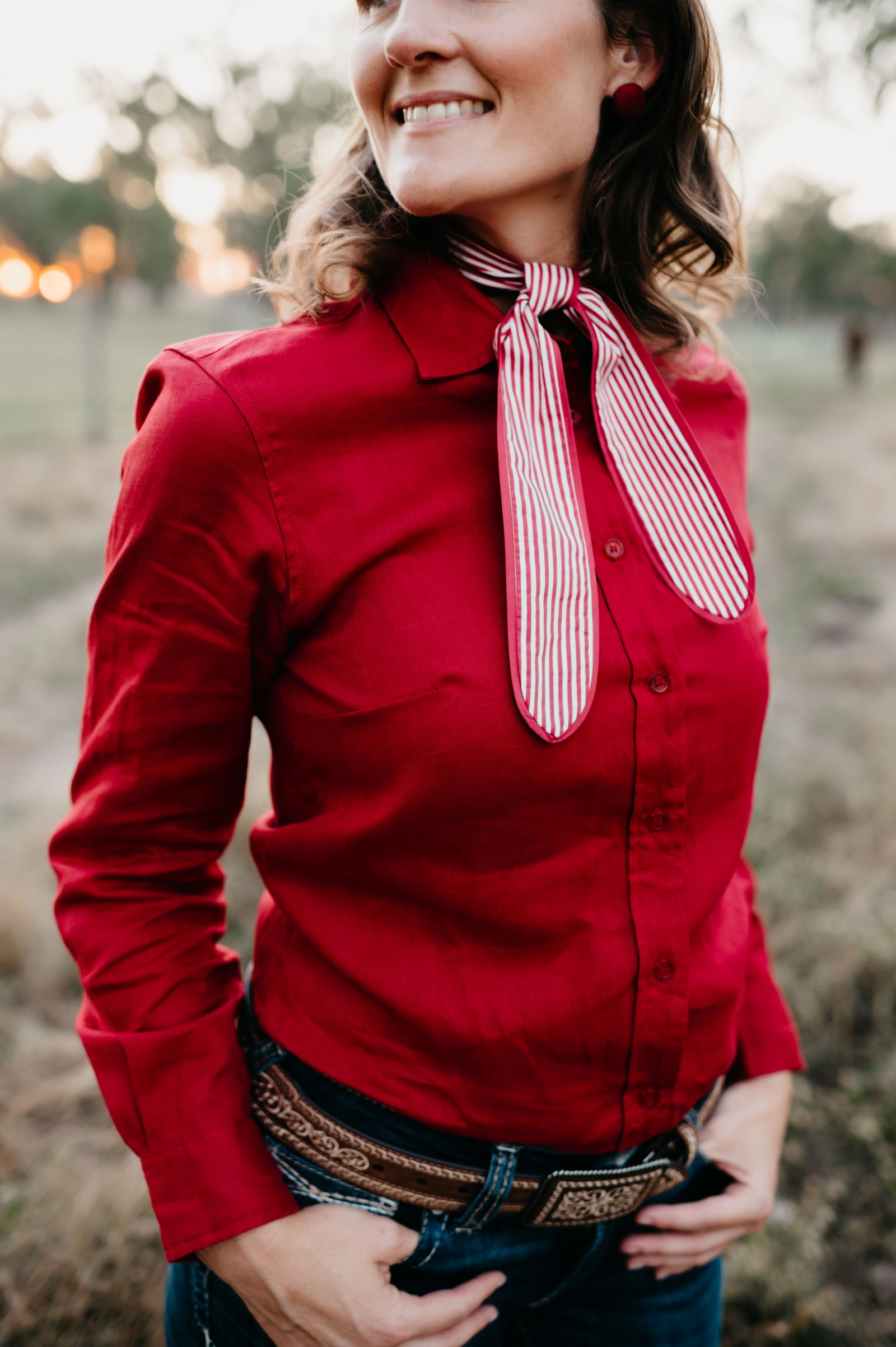 Kitty Fordè Tanielle Plain Linen L/S Shirt. Woman wearing a red blouse with a striped tie in an outdoor setting