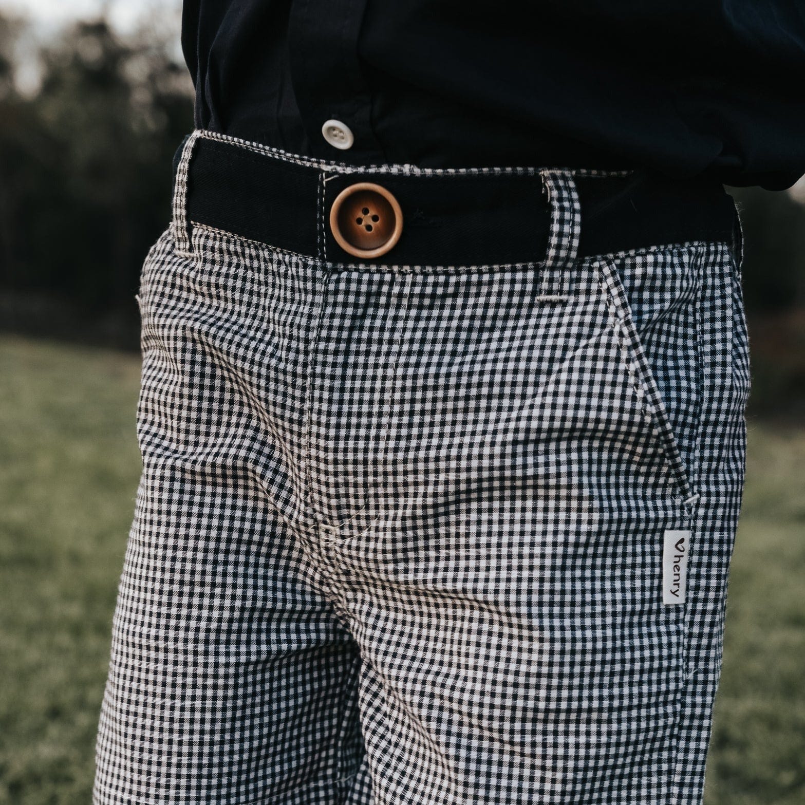 Love Henry Boy's Oscar Shorts. Navy gingham checkered shorts with a functional button fastening at the front and a decorative button on the right back pocket, featuring an elasticated waistband.