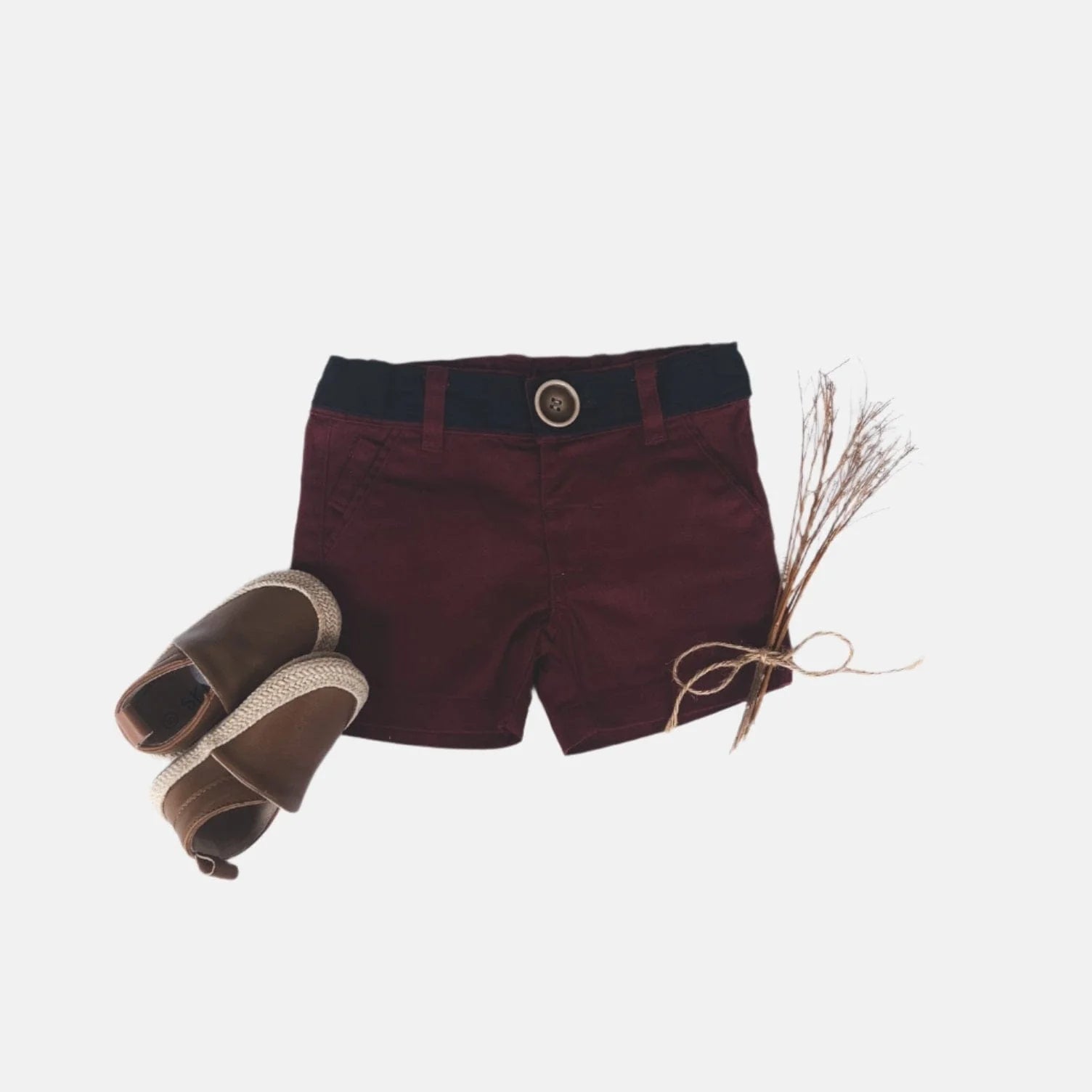 Love Henry Infant Boy's Oscar Shorts. A pair of maroon infant boy's shorts with a belt, button fastening, and pockets, accompanied by a pair of brown shoes.