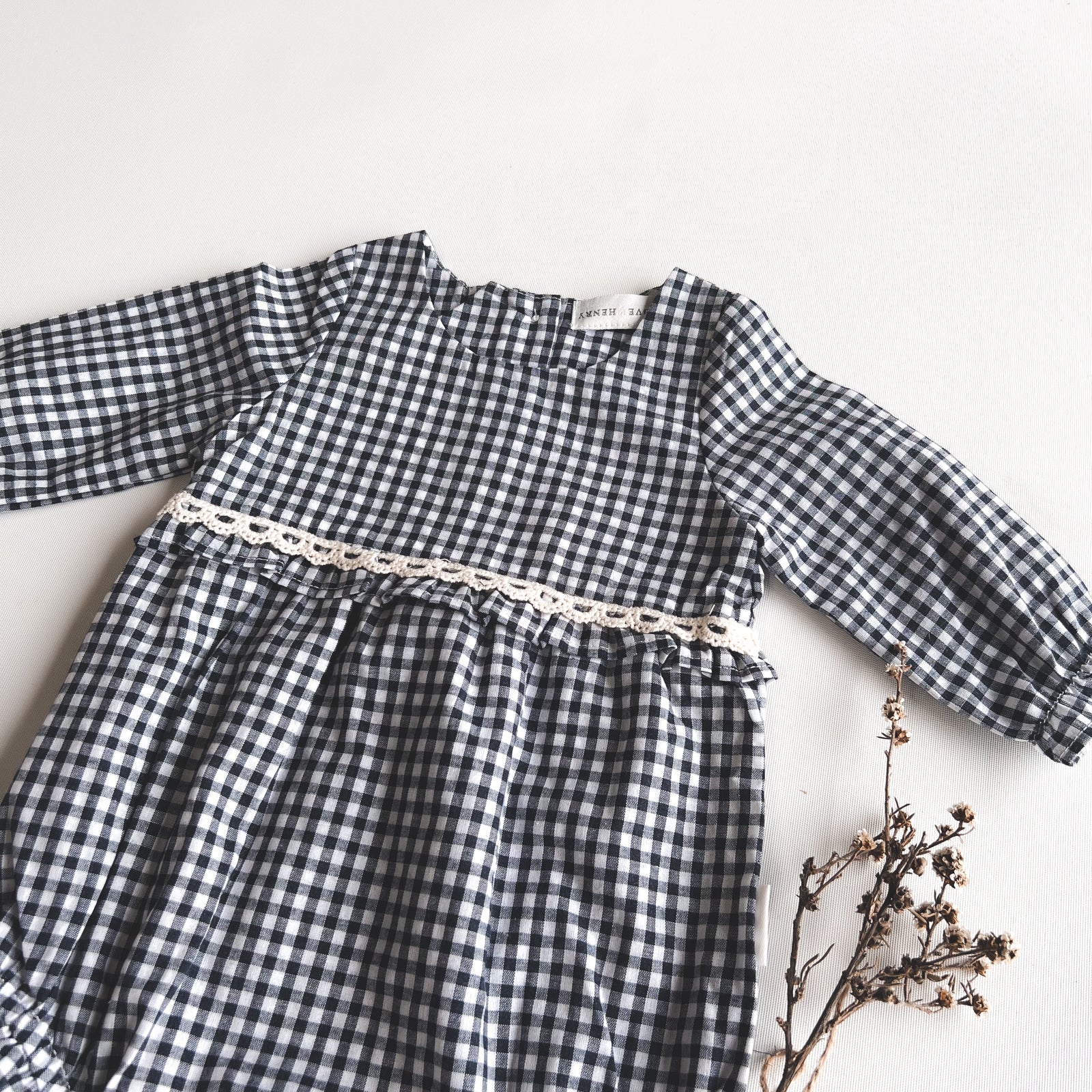 Love Henry Baby Girls L/S Nora Playsuit - Navy Check. Navy and white checkered dress with a chain detail on a white background