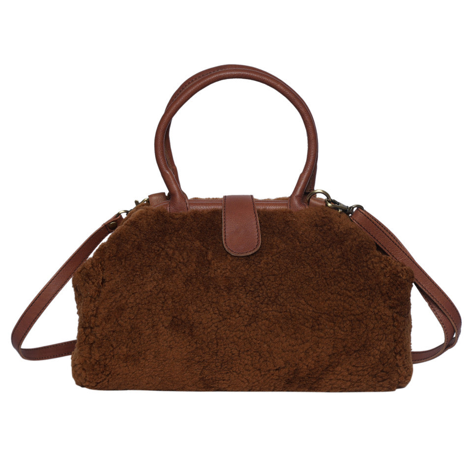 Kitty Xo Collection. A brown sheepskin and leather handbag with a structured shape and two handles.