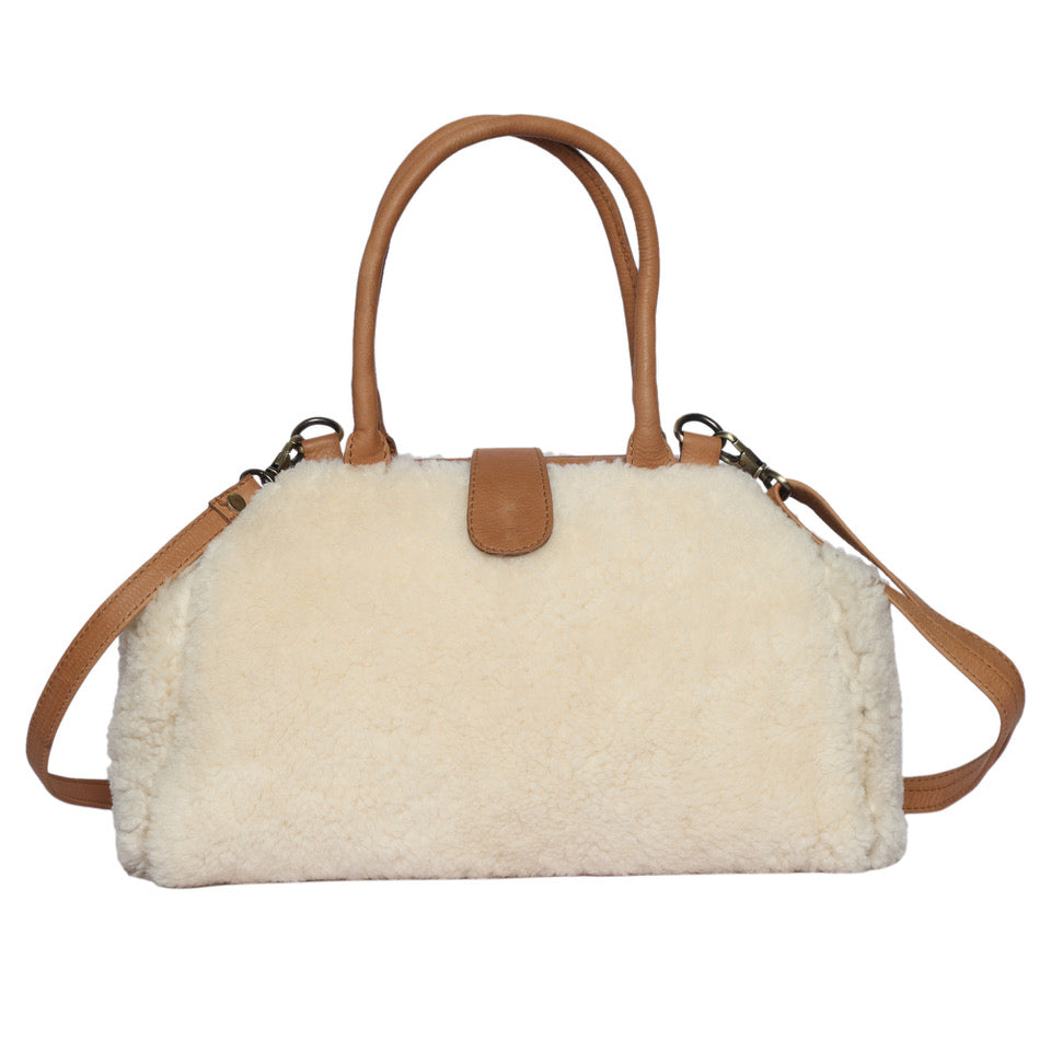 The Design Edge Women's Shearling Fur Handbag. A handbag featuring a shearling fur body with leather straps and a leather base, designed with a magnetic loop and metal frame opening.