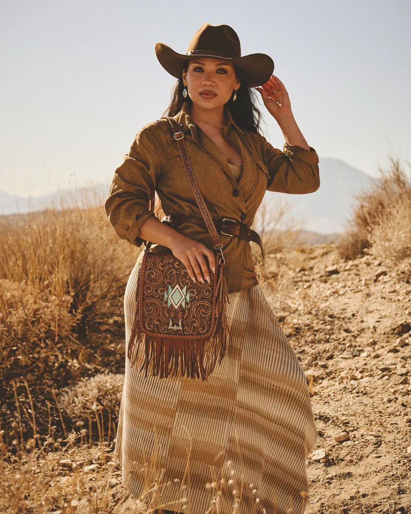 Loyal West Luciana Western Tassle Bag. Woman in a desert setting wearing a cowboy hat and carrying a patterned bag.