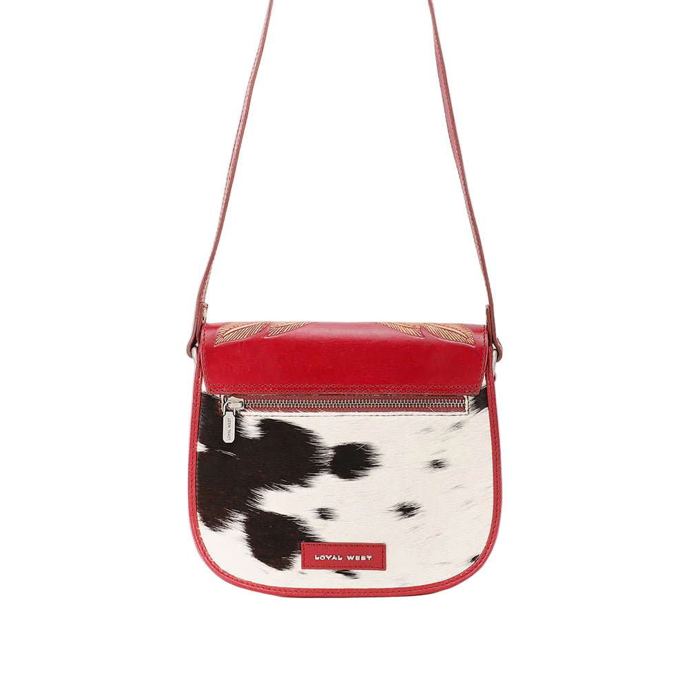 Loyal West Aurelia Mini Western Handbag. Crossbody bag with cow print design and red accents on a white background