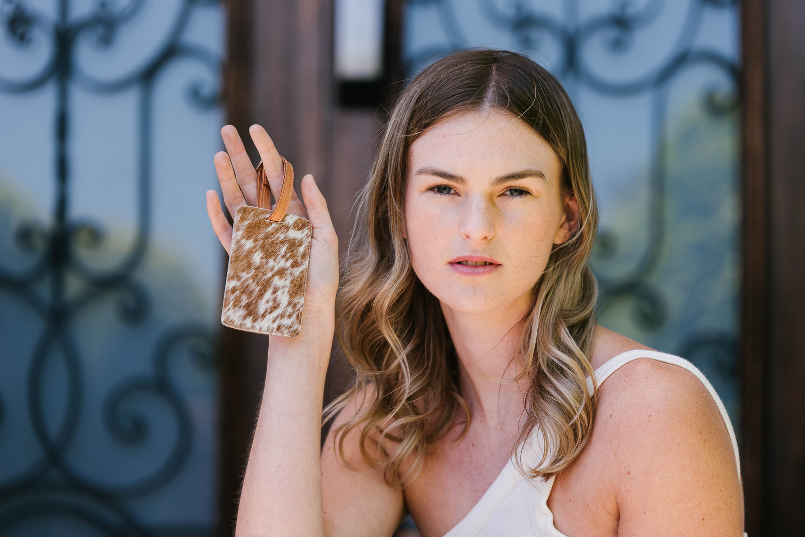 Woman holding a small decorative item in front of a blurred background