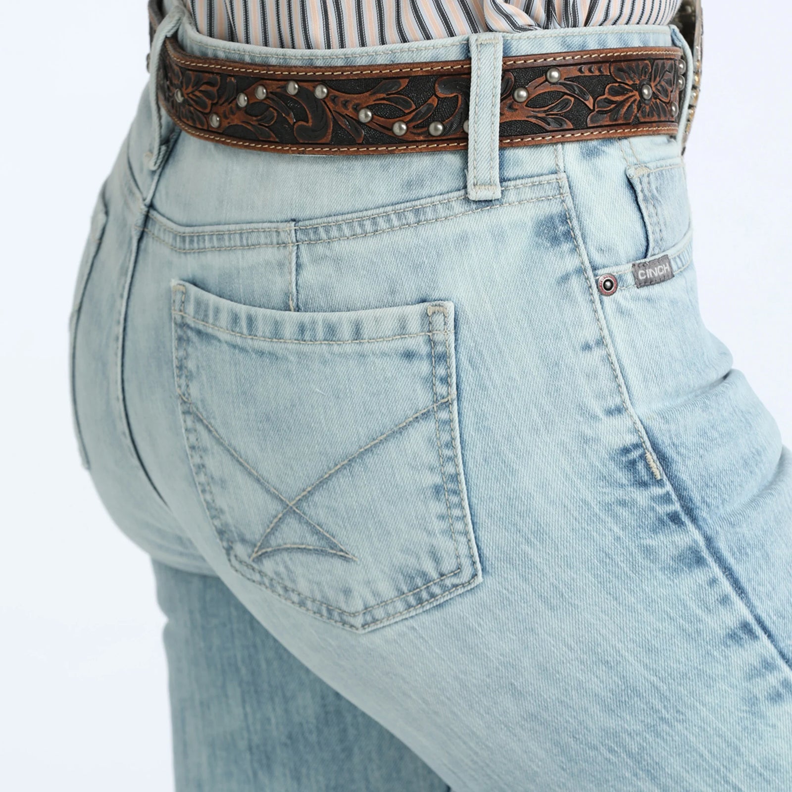 Light blue jeans with a decorative brown belt on a white background