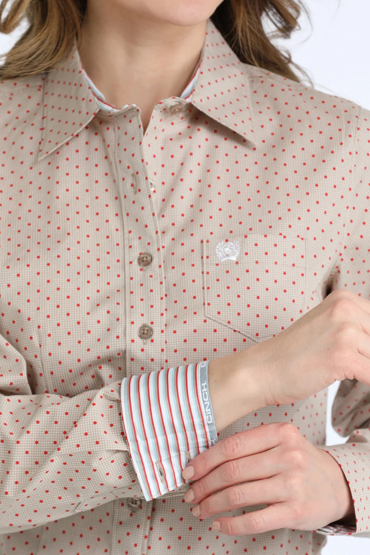 Close-up of a person wearing a patterned shirt with rolled-up sleeves.