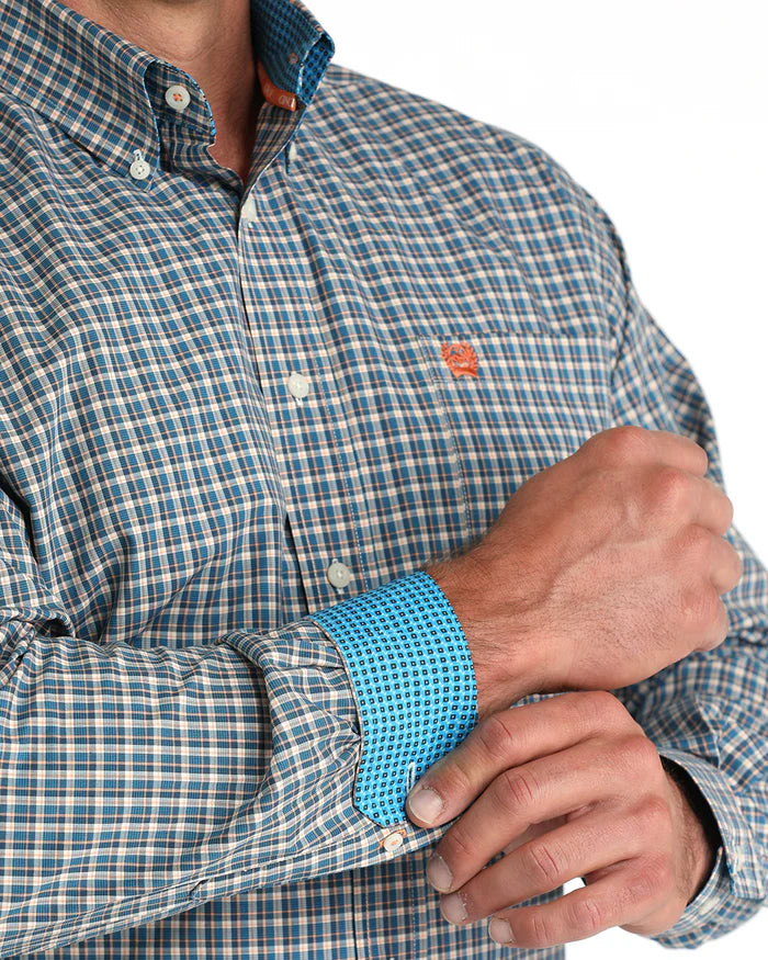 Cinch Men's Classic Fit Check L/S Western Shirt. Close-up of a person wearing a blue and white checkered shirt with rolled-up sleeves.