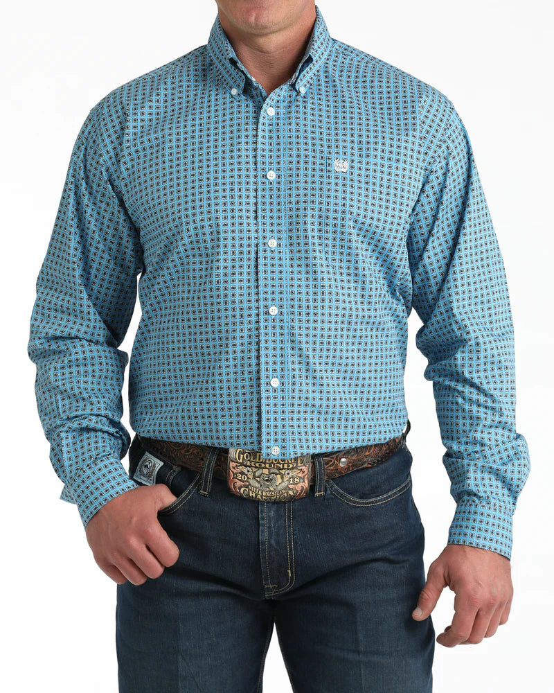 Man wearing a blue patterned shirt and jeans on a white background