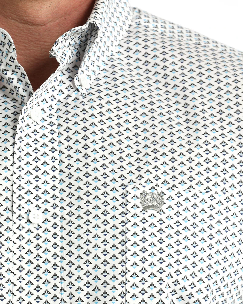 Close-up of a patterned shirt with a brand logo on a white background