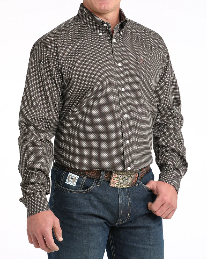 Man wearing a patterned button-up shirt and jeans on a white background
