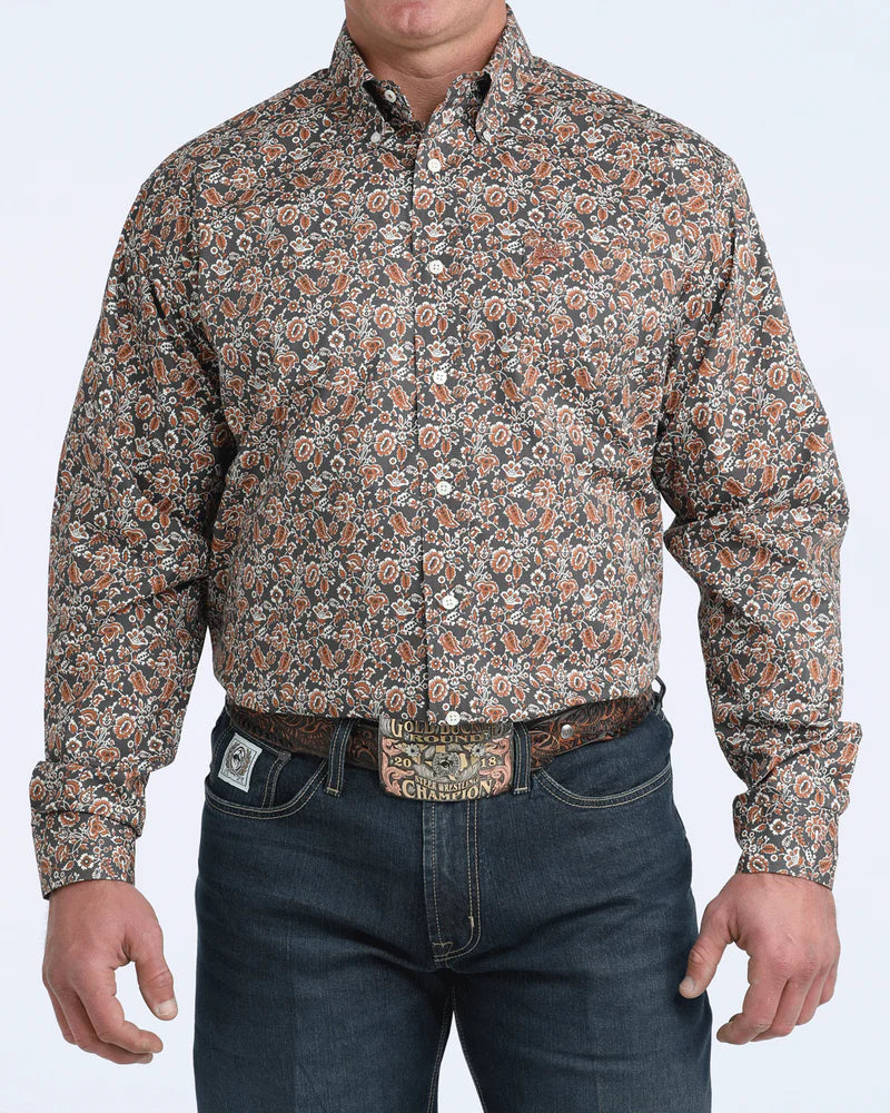 Man wearing a patterned shirt and jeans on a white background