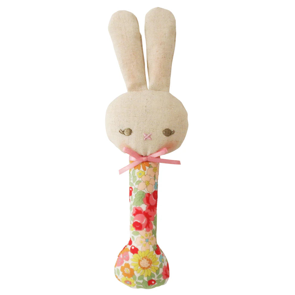 Stuffed bunny toy with floral handle on a white background