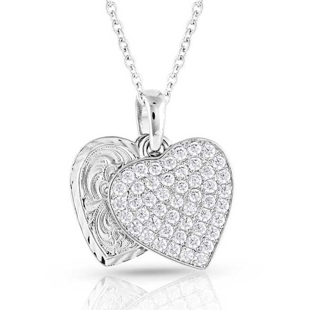 Montana Silversmiths Country Charm Crystal Love Necklace. A silver-toned necklace with two dangling heart charms, one adorned with clear cubic zirconia stones and the other with bright-cut engraving, connected to a single smooth bail on a 19 inch chain.