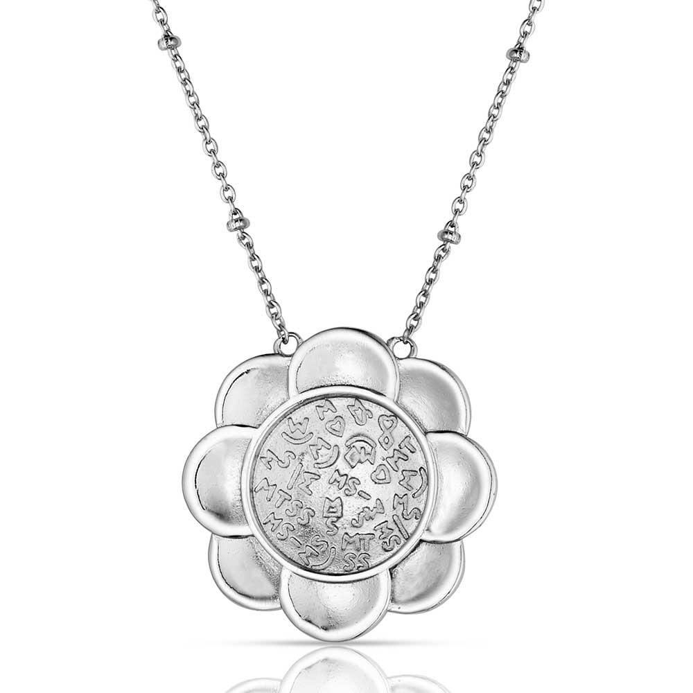 Silver flower-shaped pendant necklace on a white background