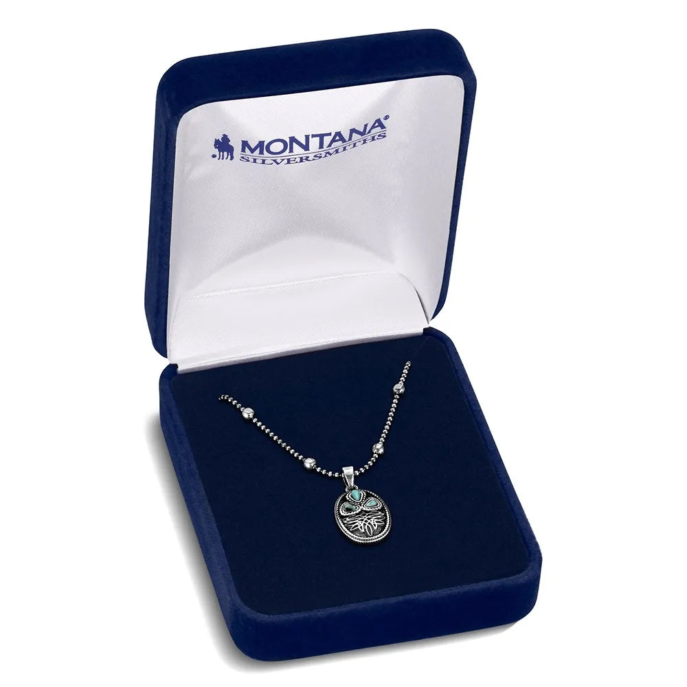 A silver pendant necklace displayed inside an open dark blue velvet Montana Silver Mines gift box on a white background.