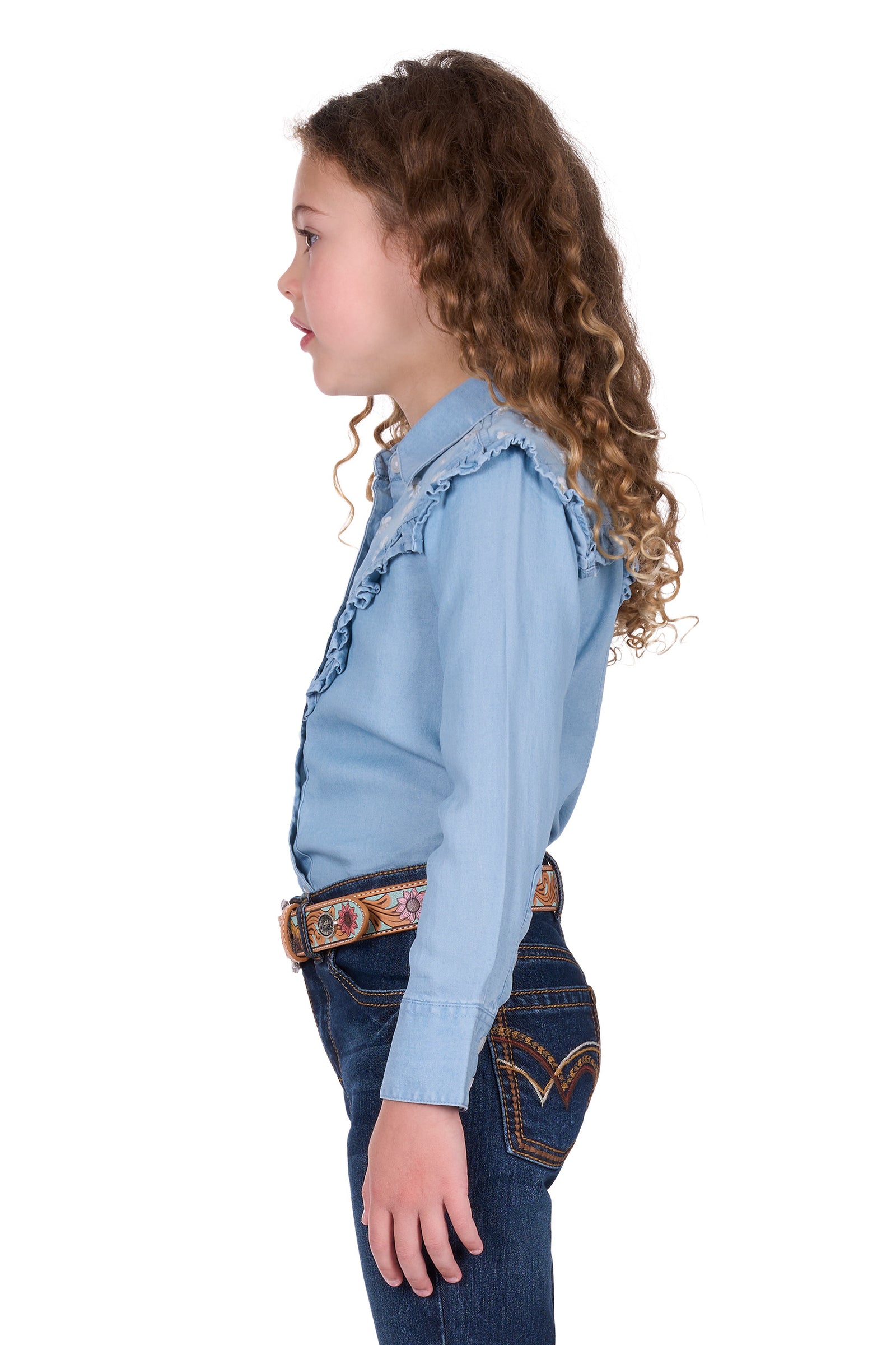Pure Western Girl's Pheobe L/S Western Shirt. Girl wearing a light blue denim shirt and jeans on a white background