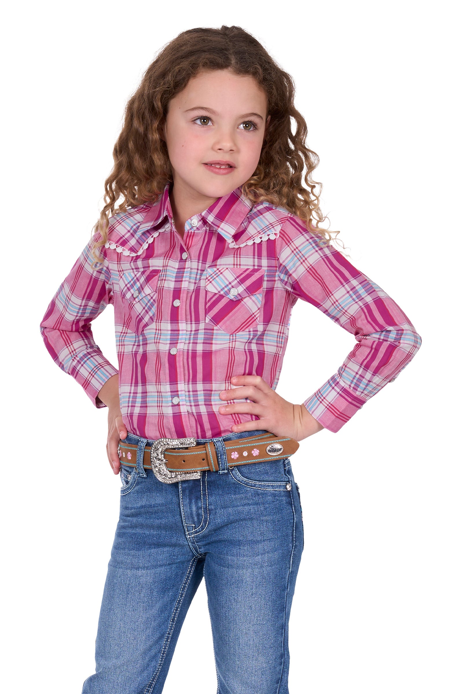 Pure Western Girl's Leni L/S Western Shirt. Young girl wearing a pink plaid shirt and blue jeans on a white background