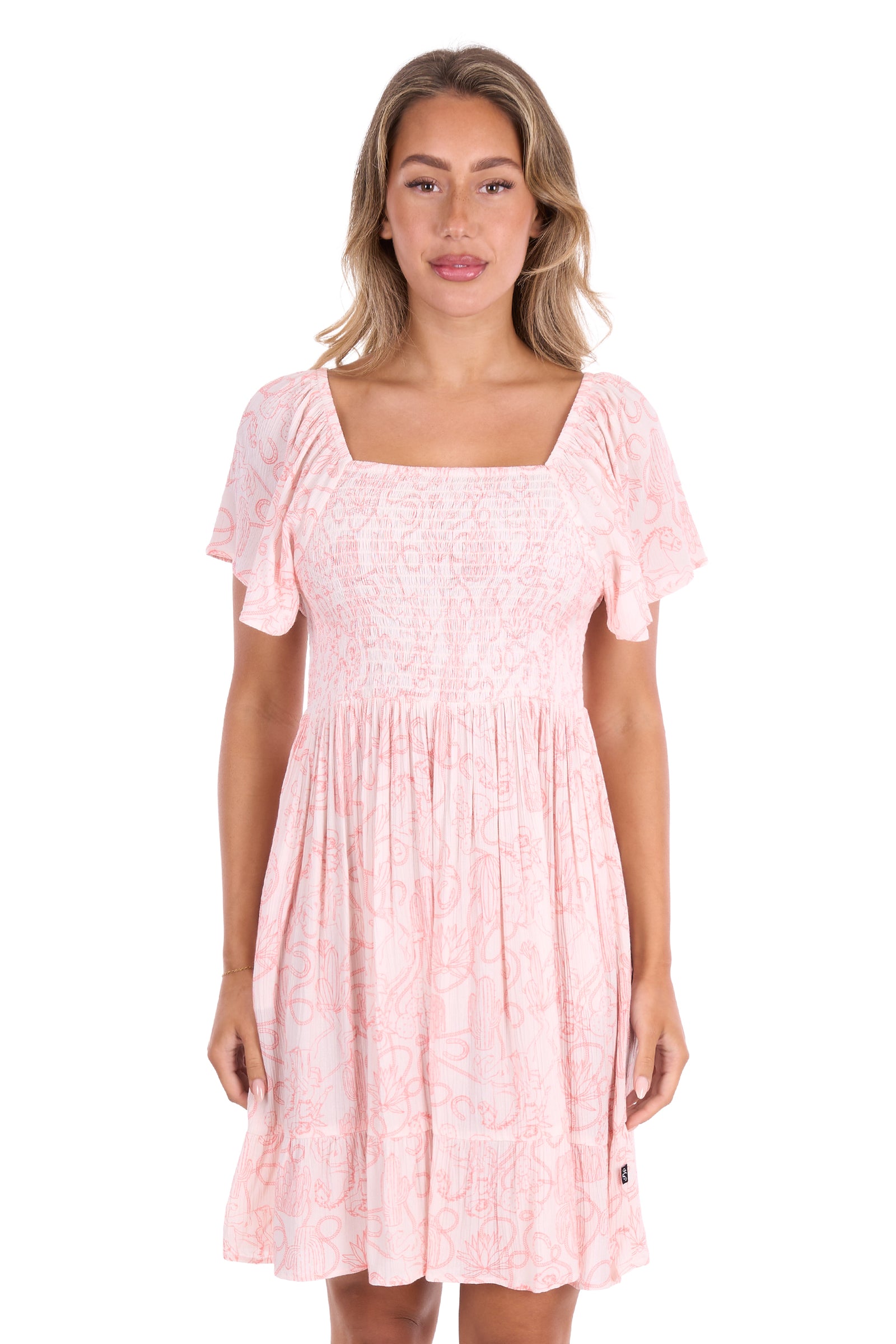 A woman modeling a light pink short-sleeve dress with a square neckline, puff sleeves, and a gathered skirt, shown against a plain white background.