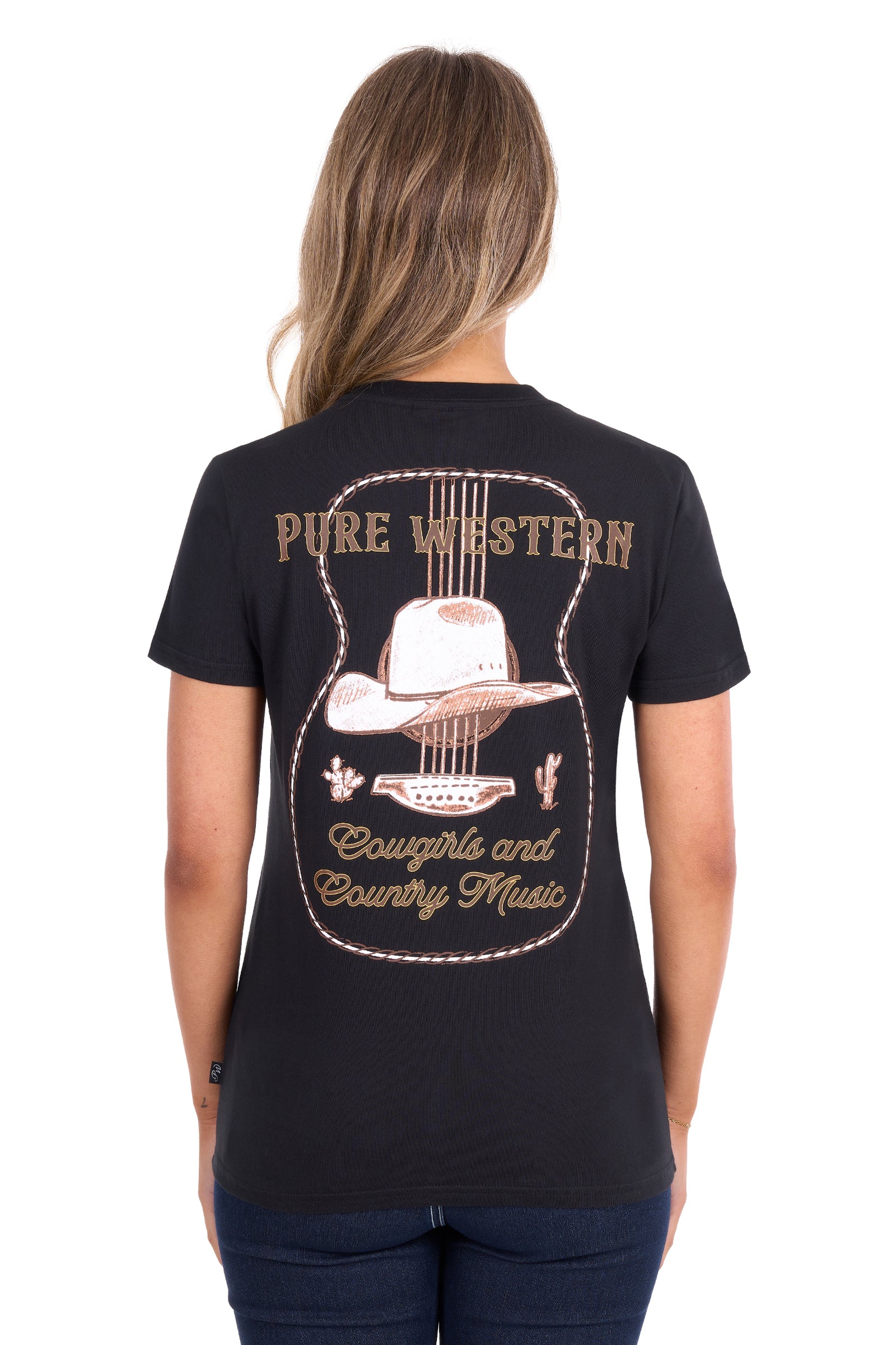 A woman viewed from the back wearing a black short-sleeve t-shirt with a large western-themed graphic on the back. The graphic features a guitar outline, a cowboy hat, and the words 'PURE WESTERN' and 'Cowgirl and Country Music' in tan and light brown lettering.