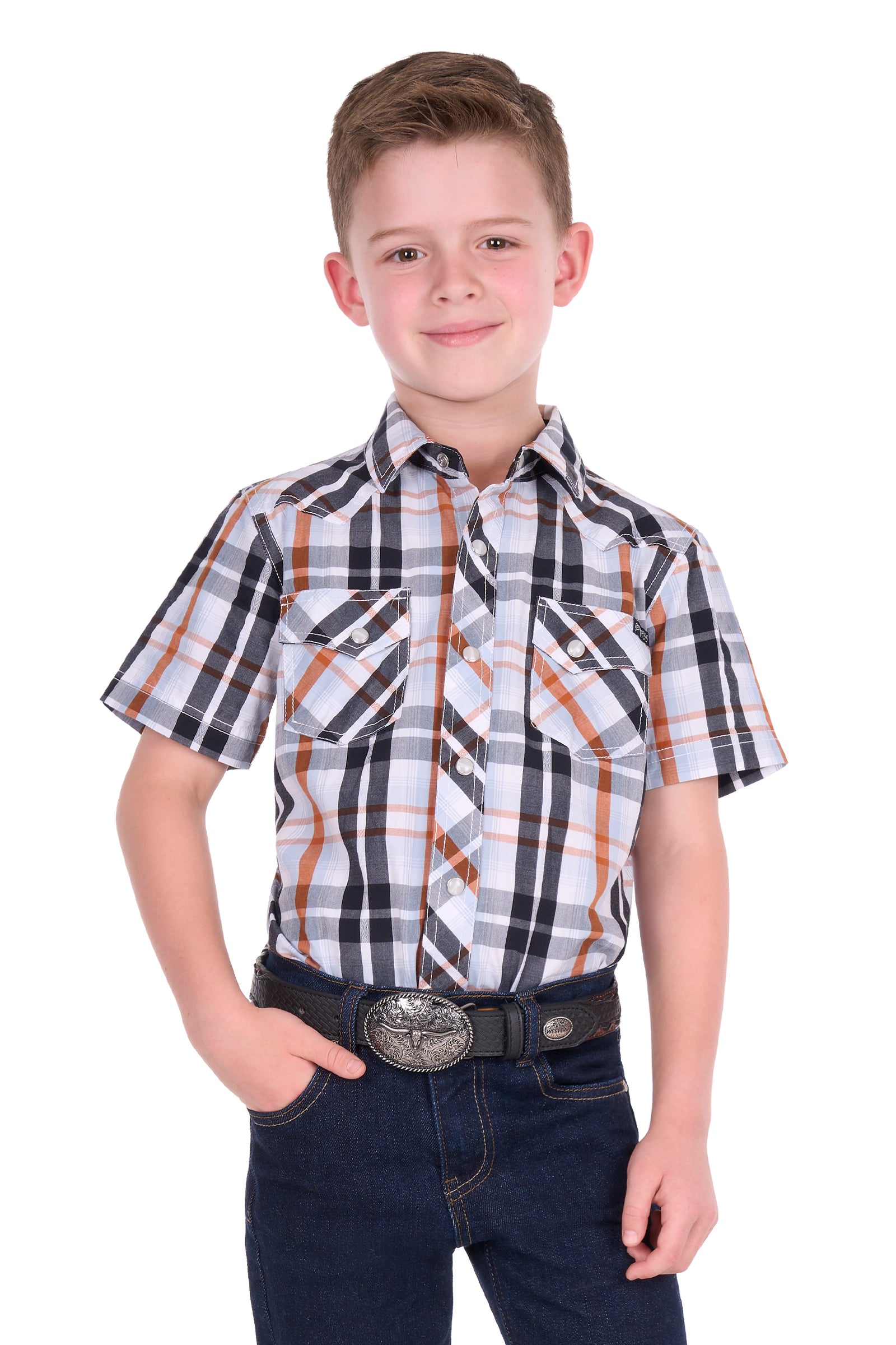 A young boy modeling a short-sleeve plaid button-down shirt with dark blue jeans and a western belt, shot against a solid white background.