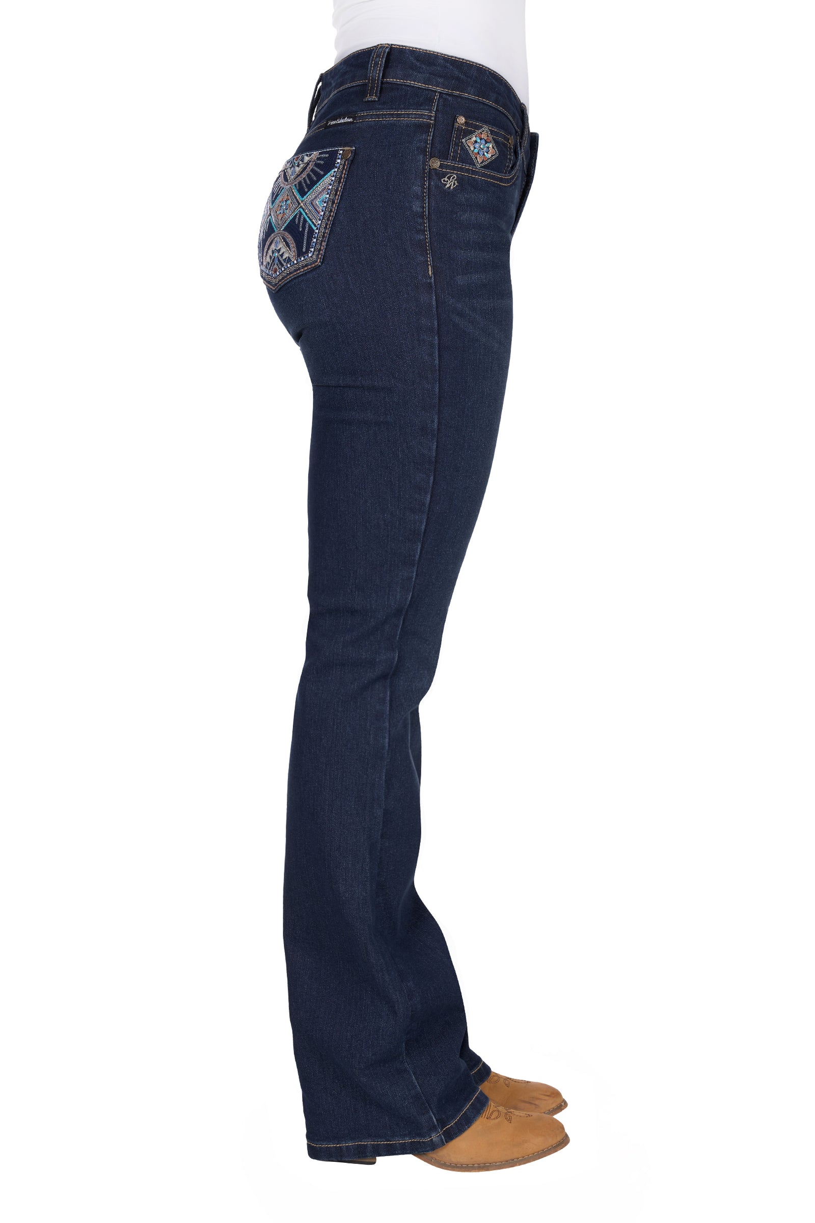 Pure Western Women's Ana Boot Cut Jean. Dark blue jeans with a decorative patch on a white background