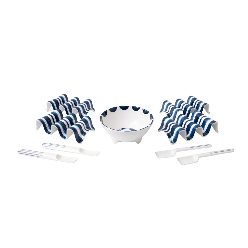 Set of white bowls with blue stripes and cutlery on a white background